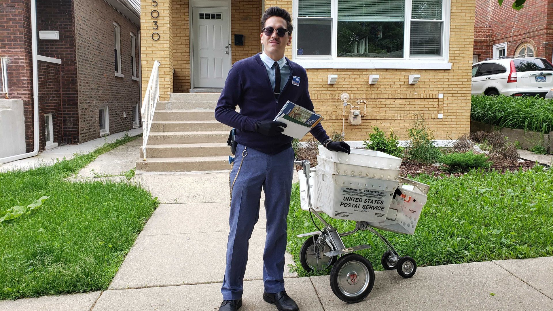 Photo of a mailman on the street. 