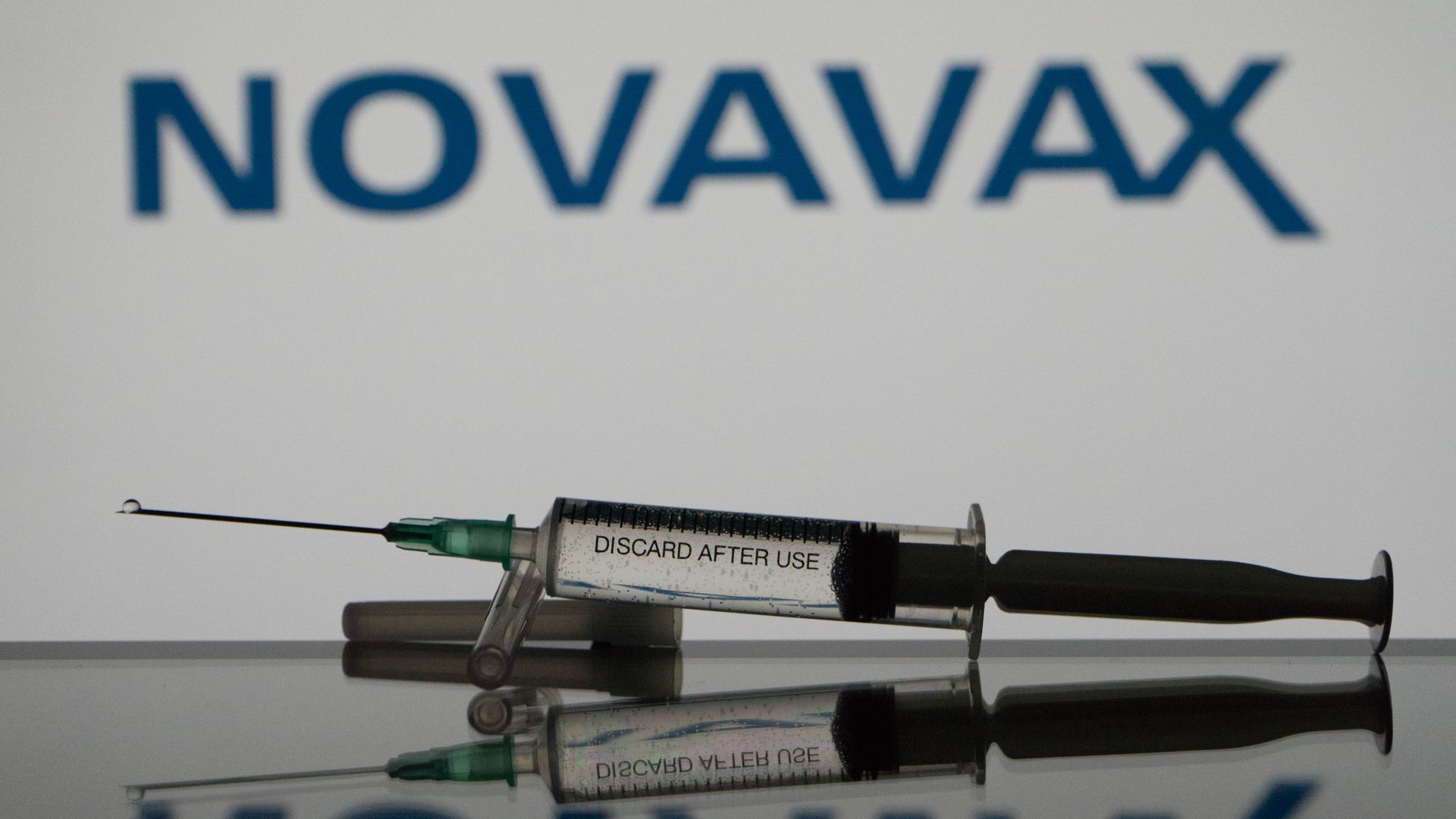  A photo illustration a covid-19 vaccine is seen with the Novavax logo in the background.