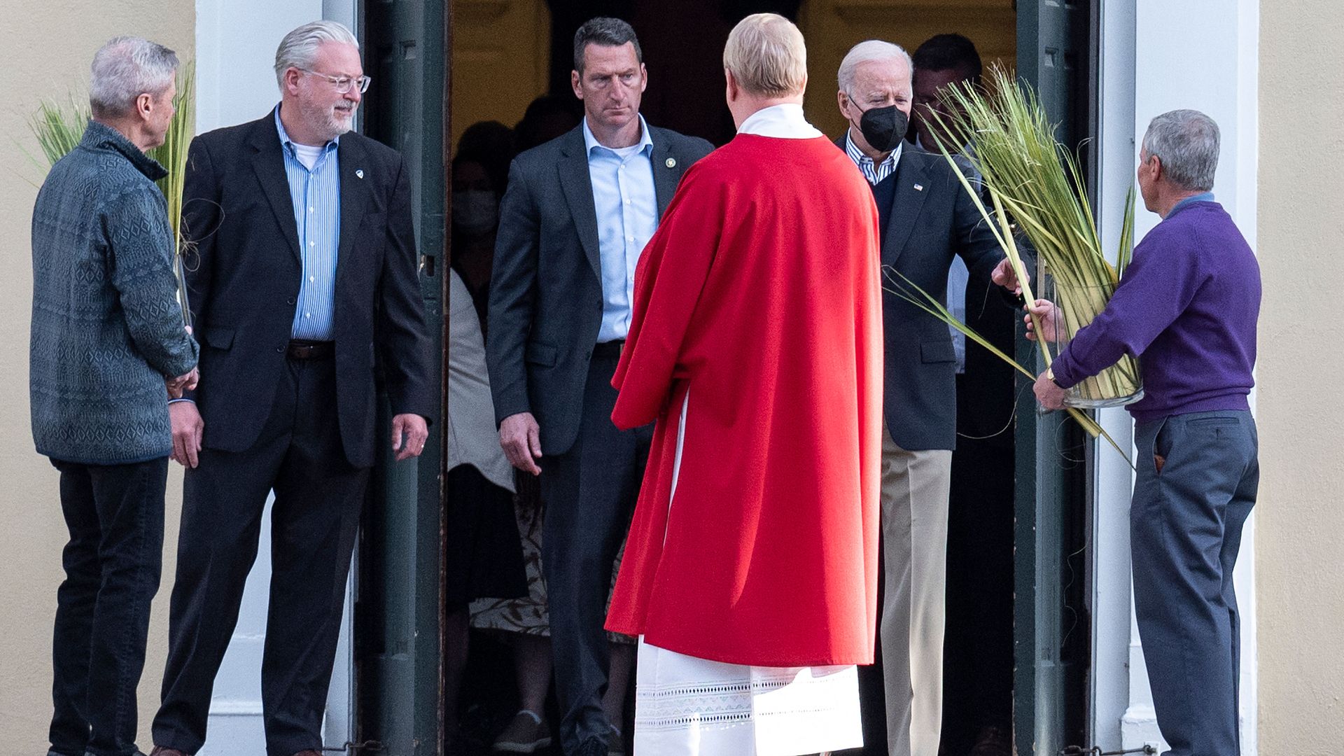 President Biden is seen receiving a palm frond as he left Mass on the eve of Palm Sunday.