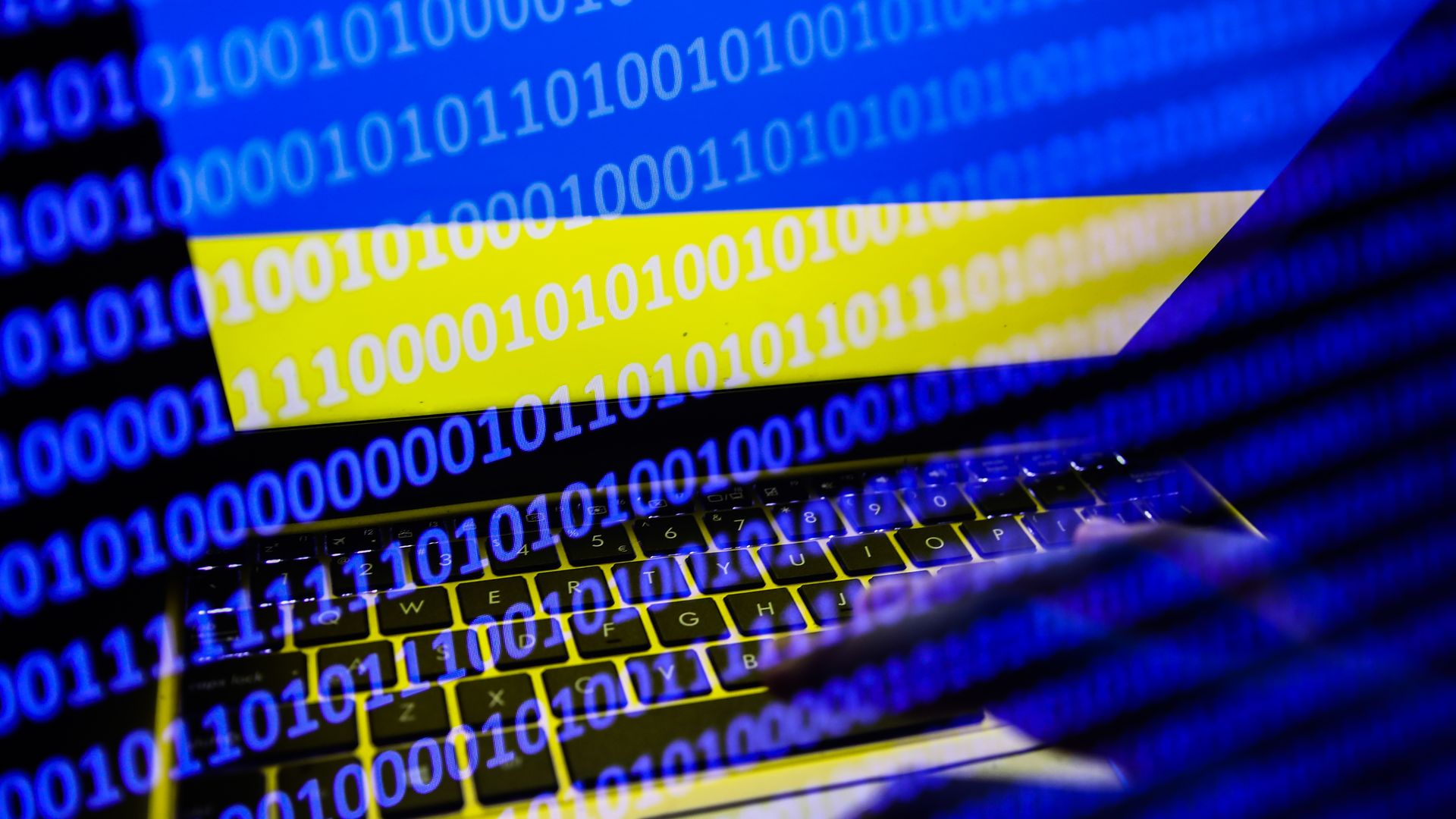 Ukrainian flag displayed on a laptop screen and binary code code displayed on a screen
