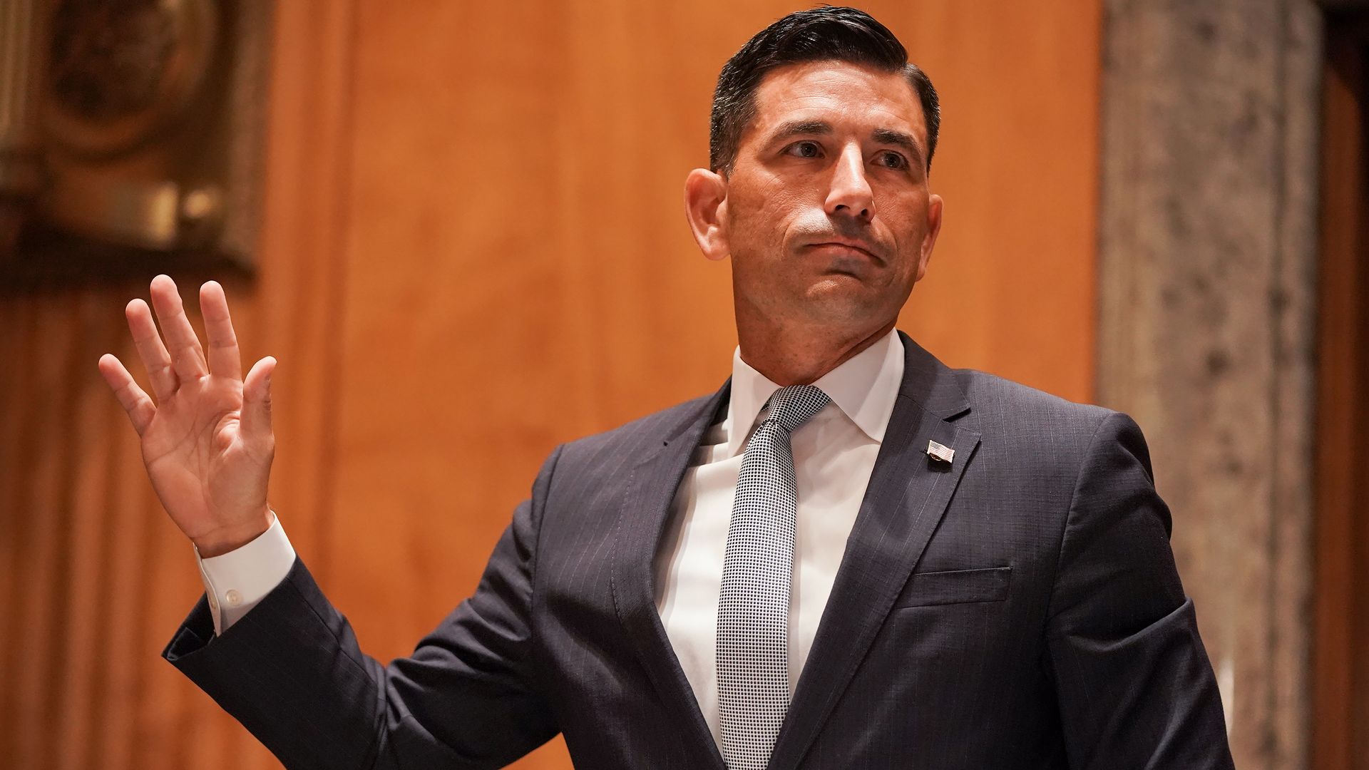 Former Acting DHS Secretary Chad Wolf raising one hand in a Congressional hearing
