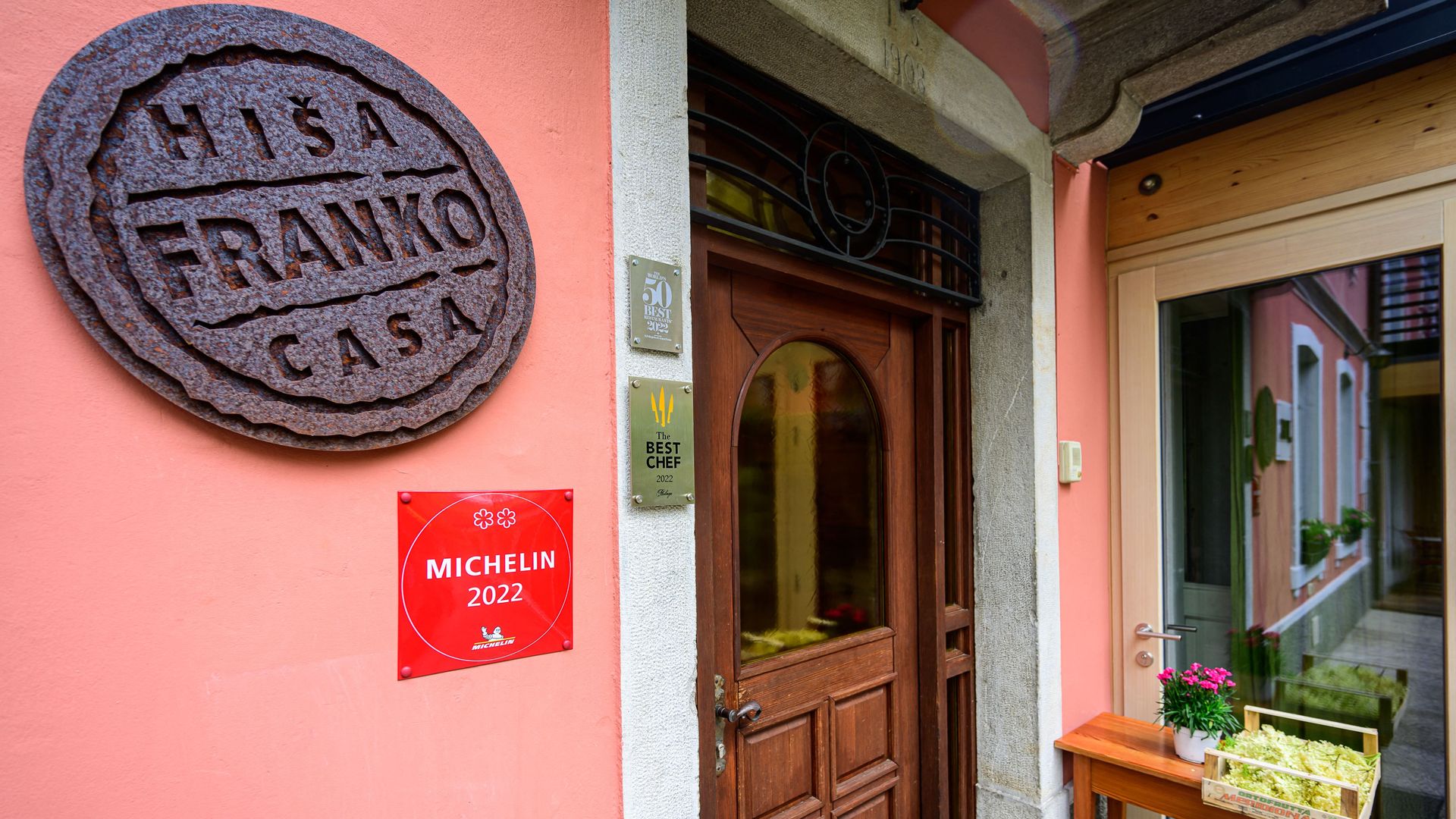 The exterior of a restaurant has a red plaque that says "MICHELIN 2022" on the wall.