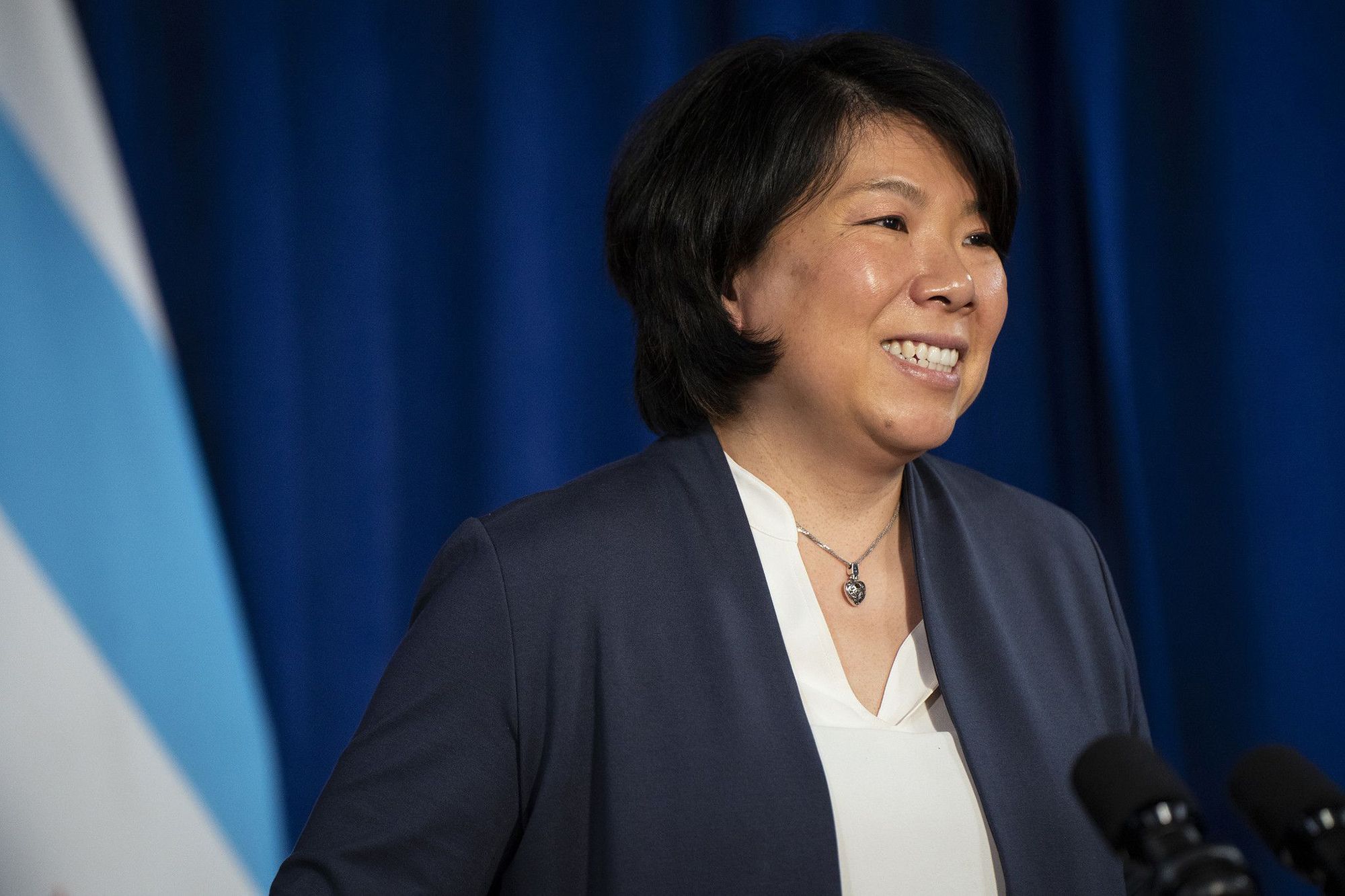 Photo of a woman smiling at a press conference. 