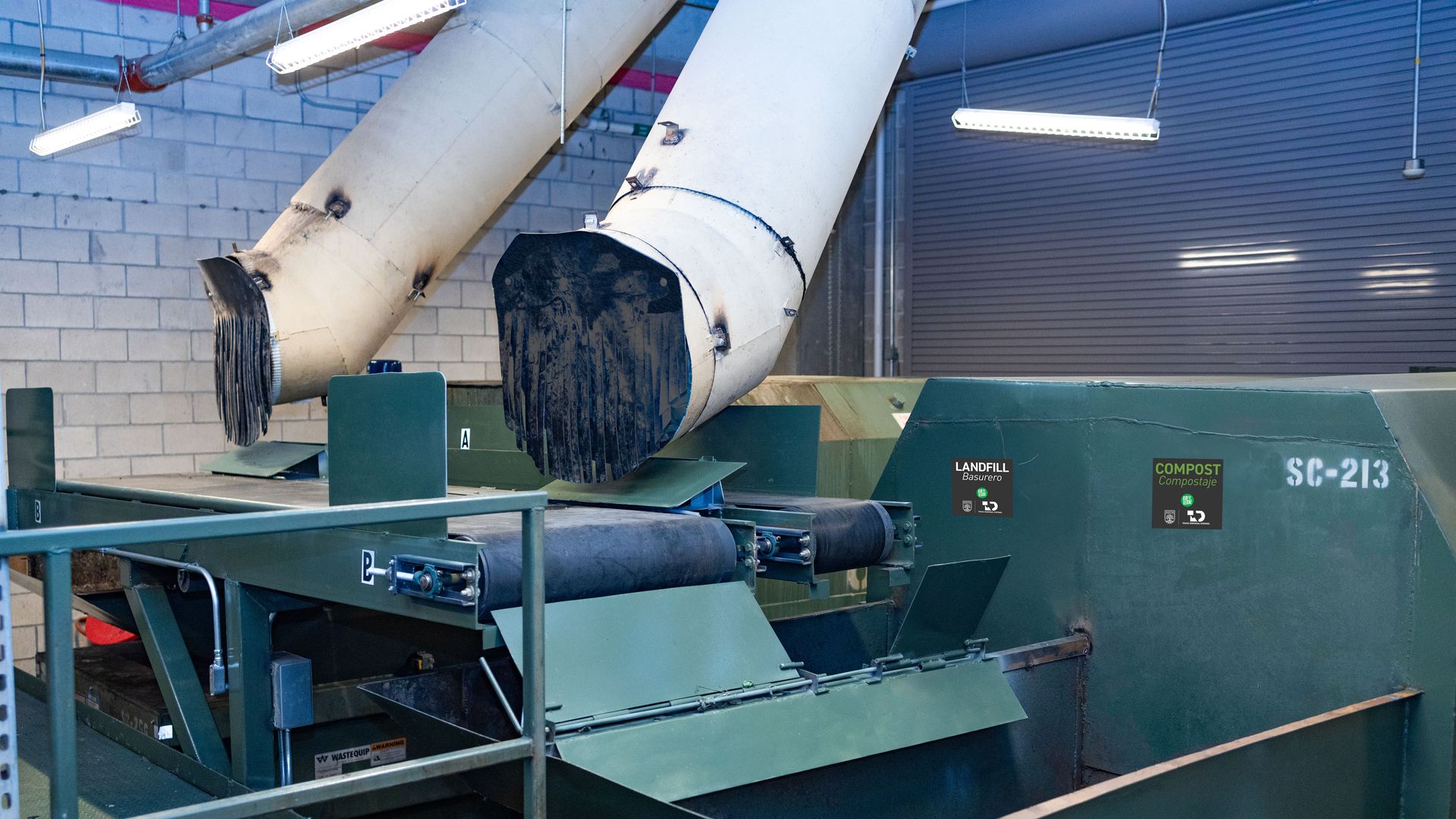 A photo of two chutes running down toward a green belt.