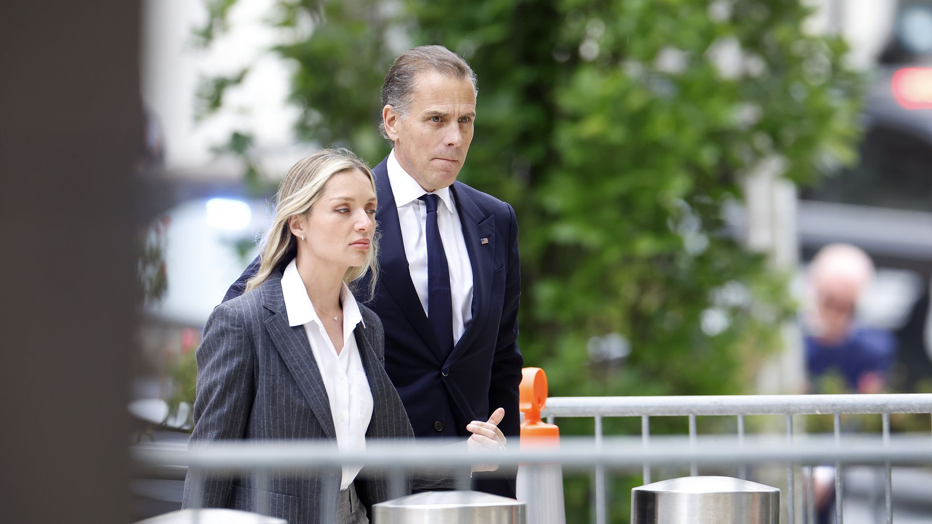 Hunter Biden and Melissa Cohen Biden enter the court room. They are outside and walking through metal fences.