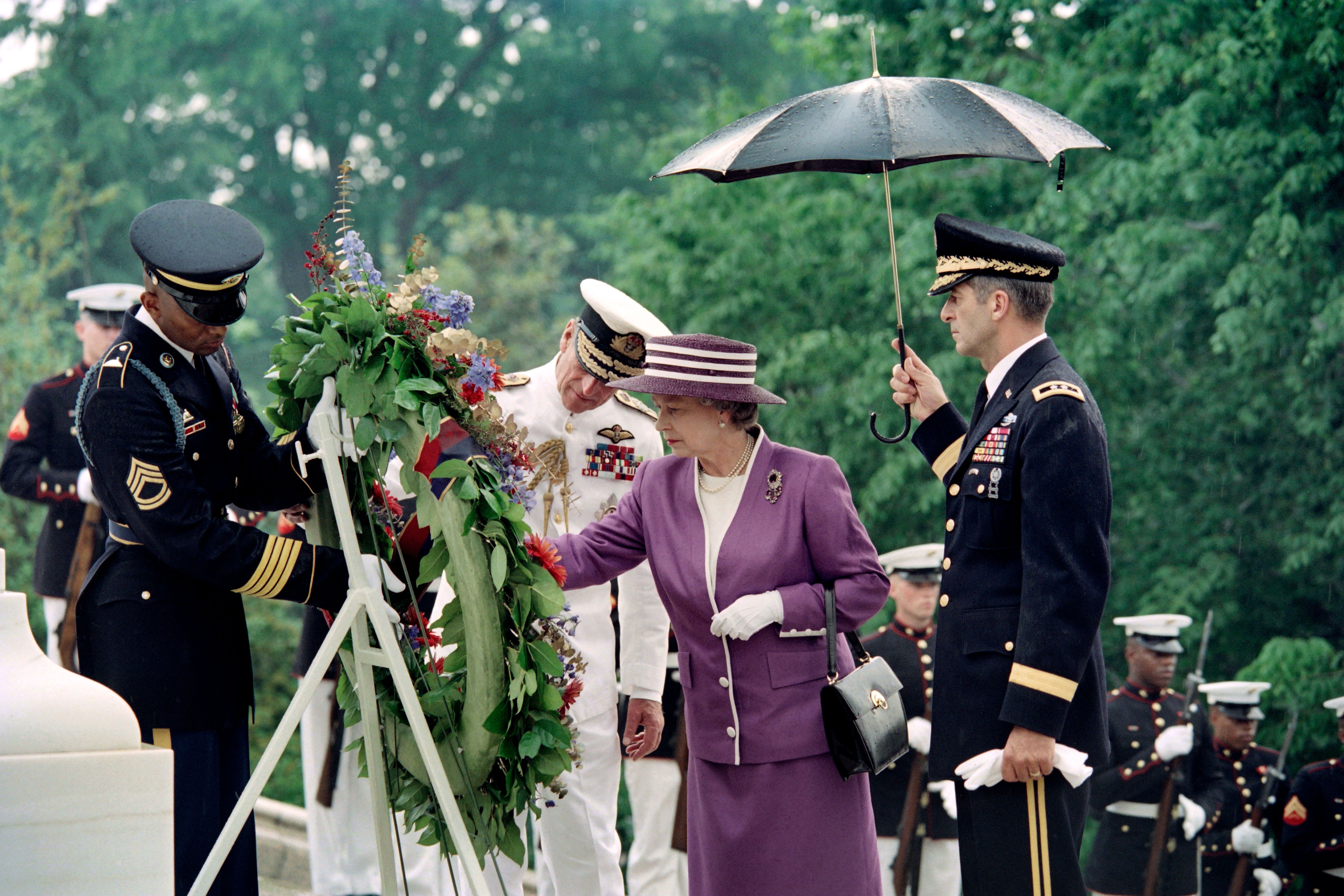 Britain's Queen Elizabeth II (R) lays a wreath at the Tomb of the Unknown Soldier on May 14, 1991 at Arlington National Cemetery, as Prince Philip, Duke of Edinburgh (C) looks on.