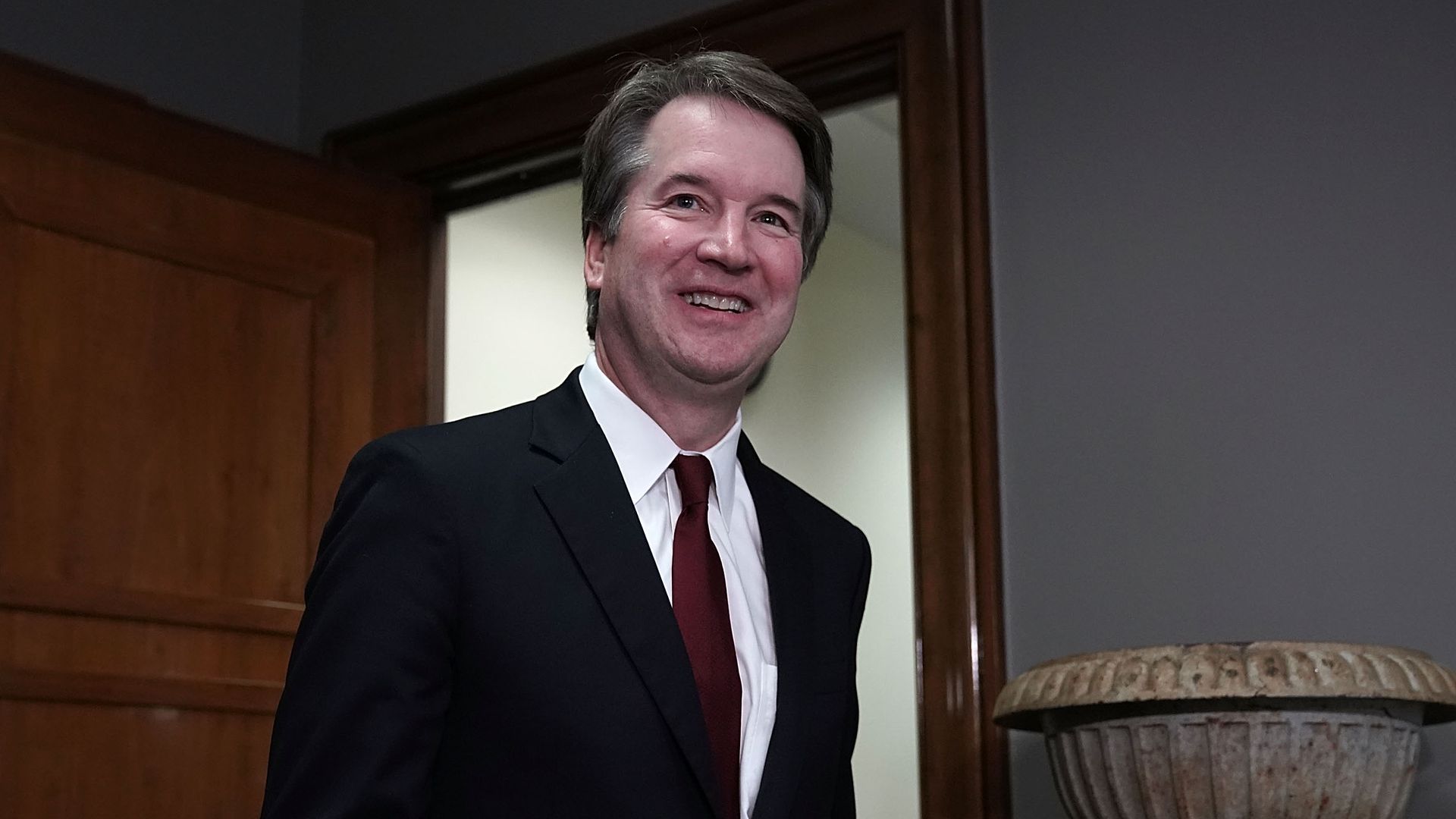 Brett Kavanaugh walks into a room on the Hill with a big grin on his face