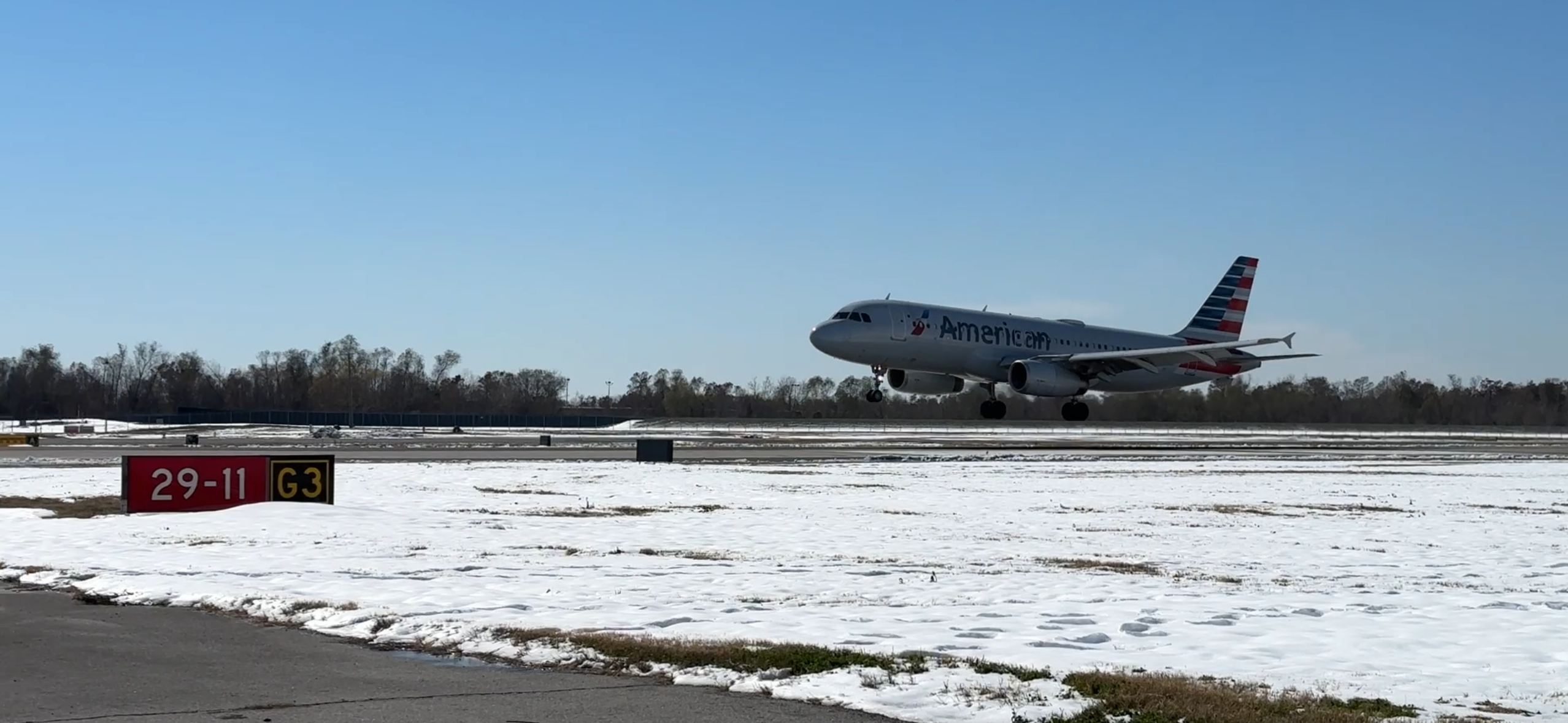 Photos shows a plane landing at a snowy airport.
