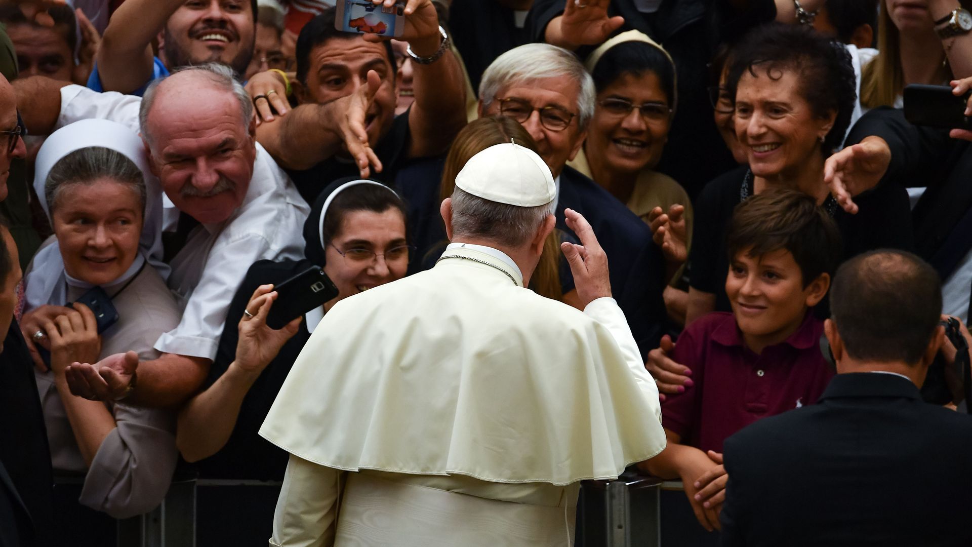 Pope Francis standing in front of a crowd.