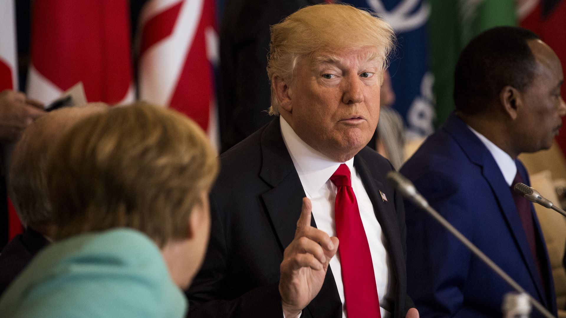 Trump holds up a finger while speaking to Angela Merkel