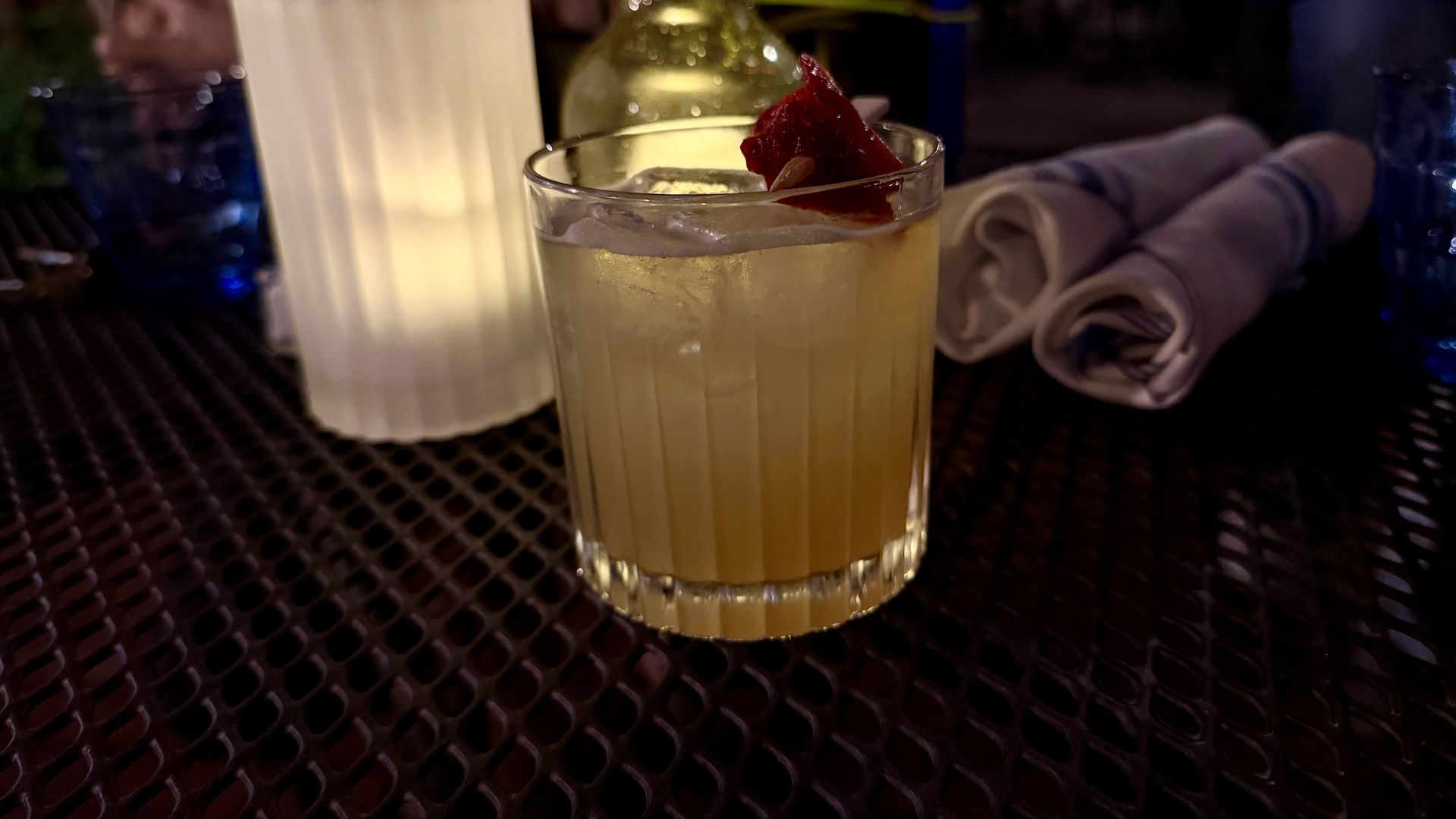 A yellow cocktail on a table at Midnight Morning in Roxbury. The drink, called "Every Woman," contains Mijenta Blanco Tequila infused with yuzu and peach green tea, along with flora house cordial and lime.