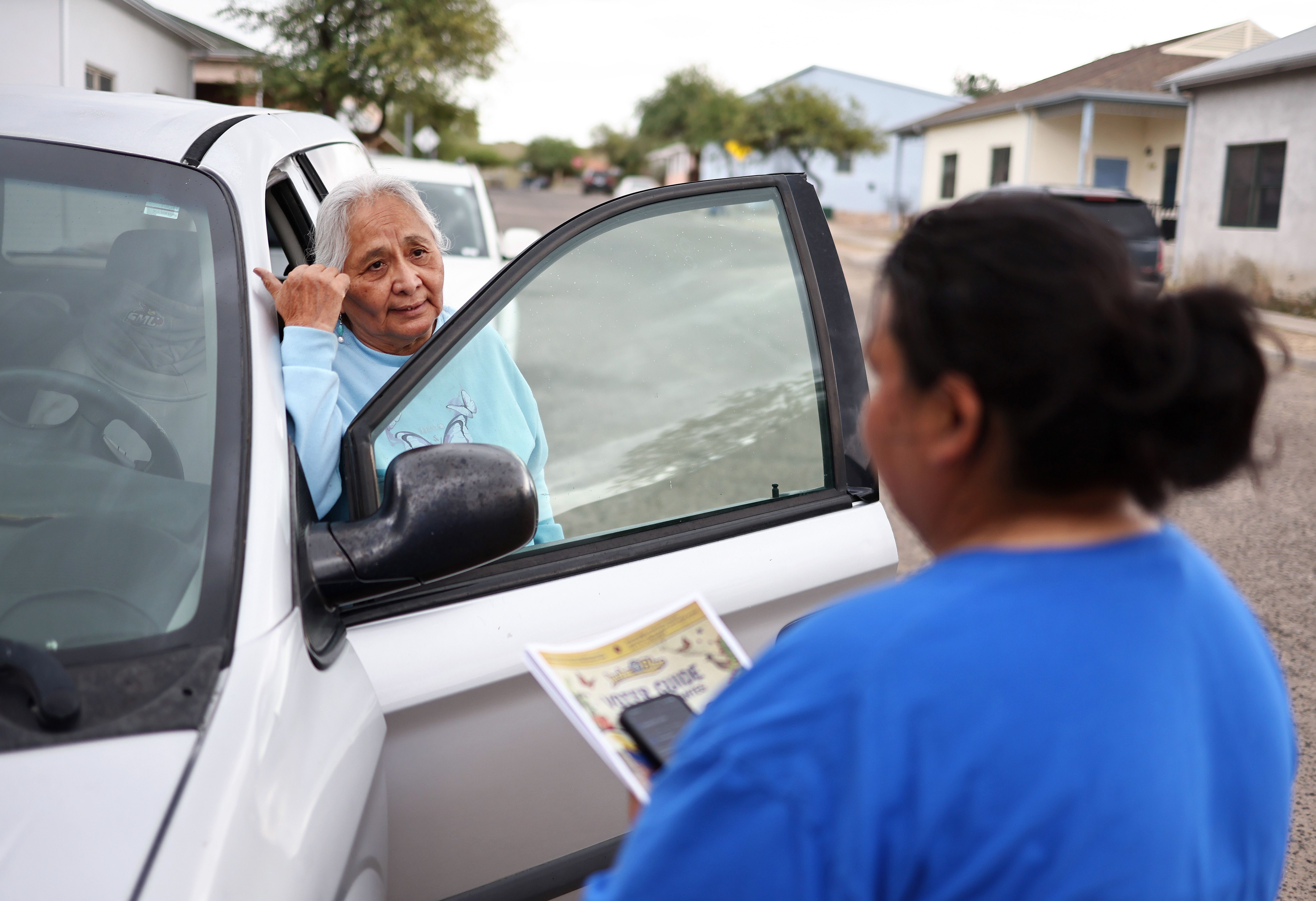 Lucha Arizona canvasser Lucianna Lopez (R) speaks with a voter while canvassing before Election Day, on November 03, 2024 in Tucson, Arizona.