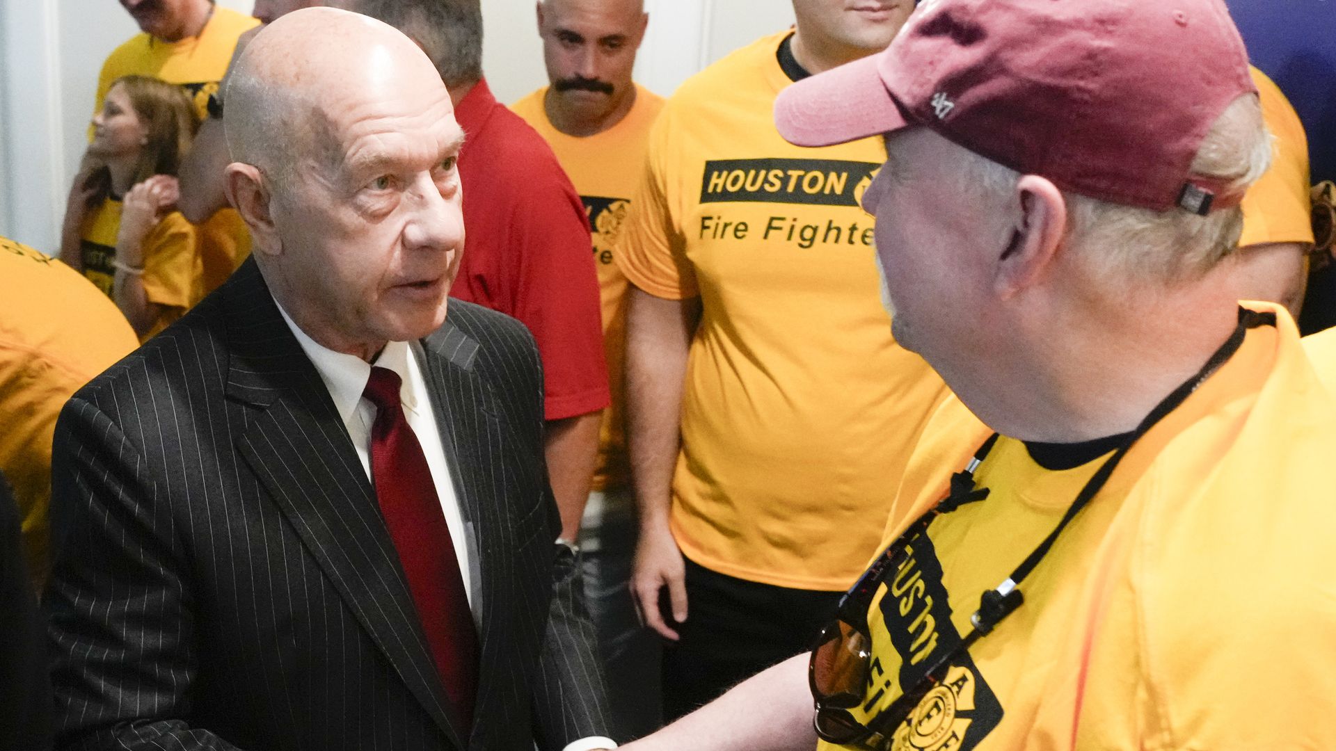 Mayor John Whitmire shakes hands with a firefighter 