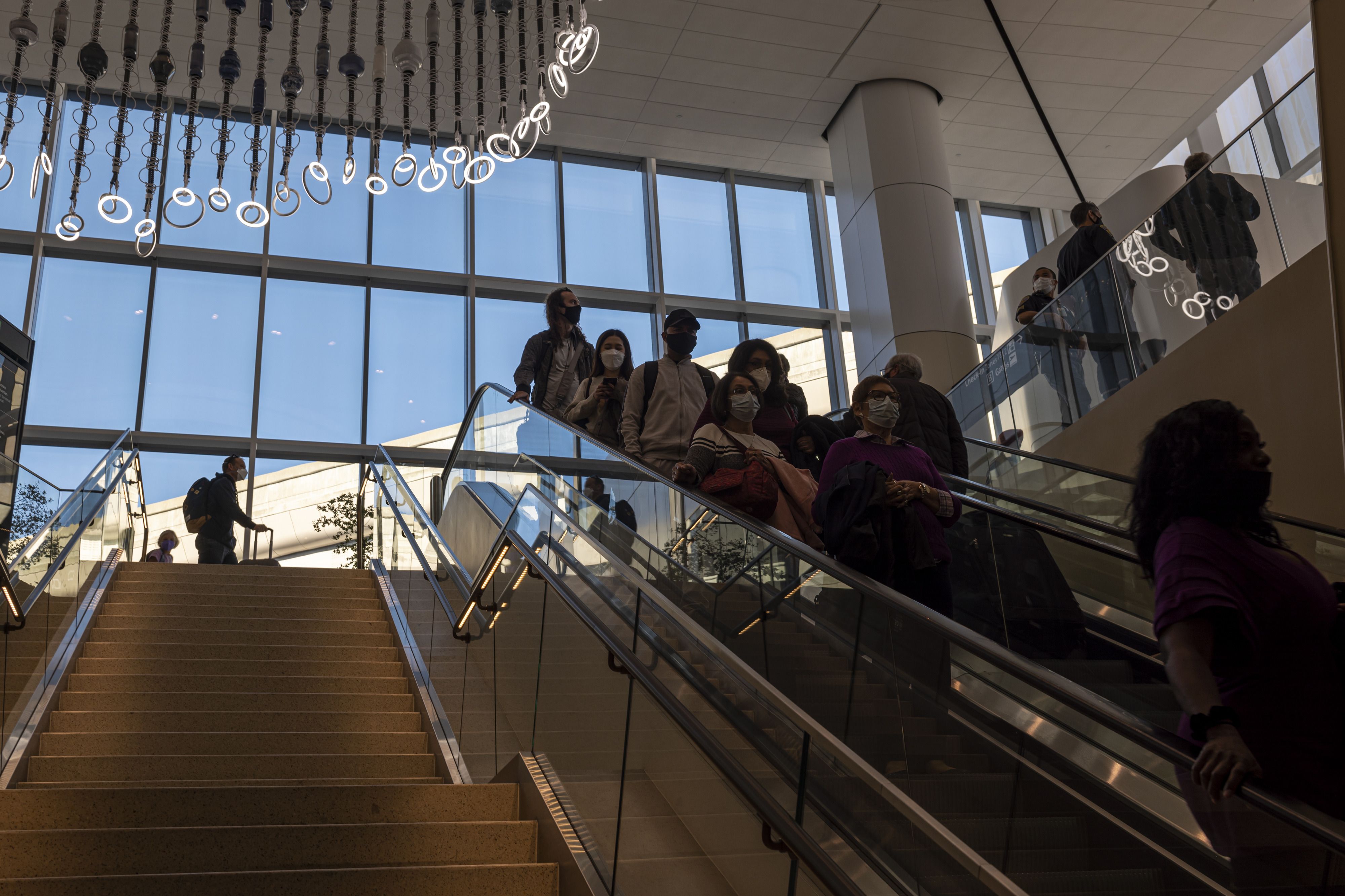 Photo of people coming down an escalator at an airport