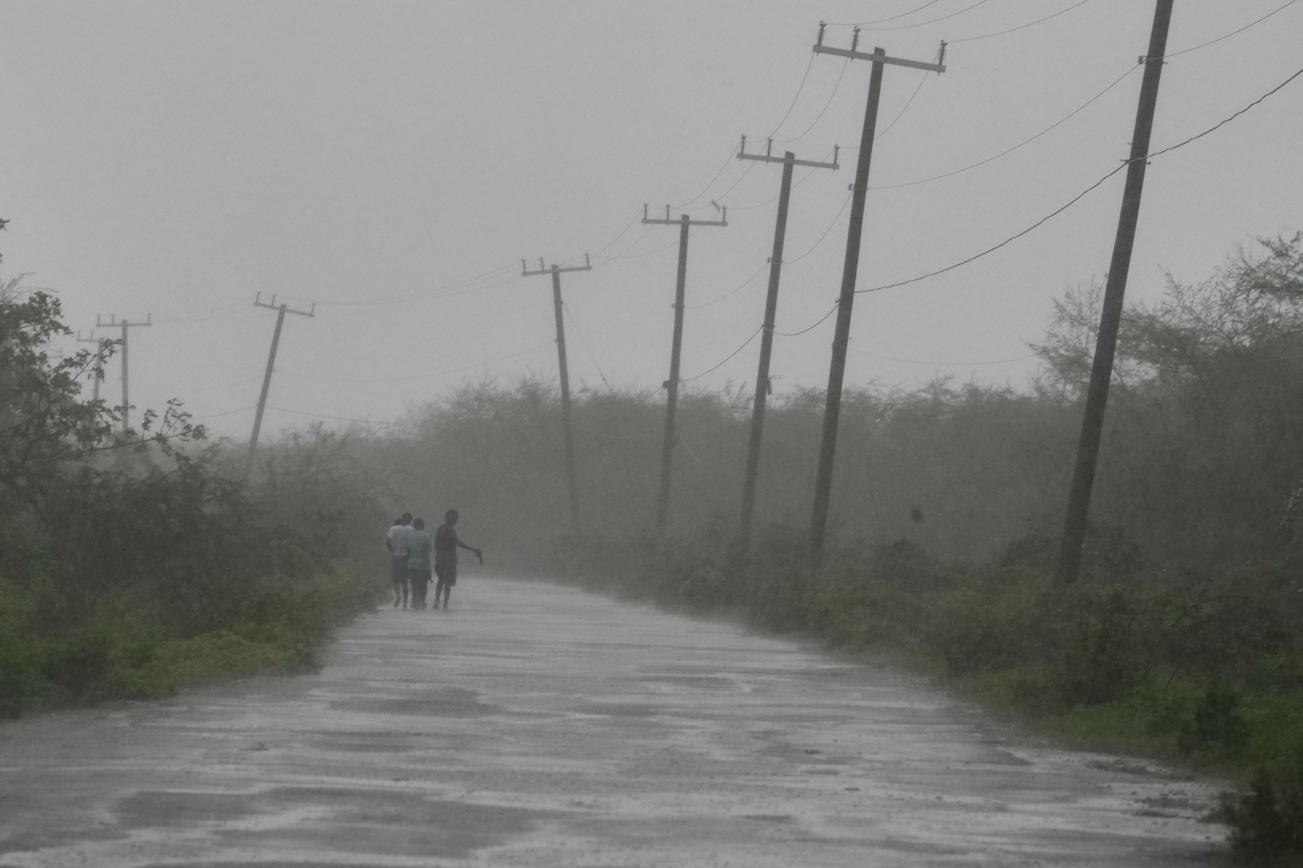 People walk along a road during Hurricane Melissa in Rocky Point, Jamaica —about 50 miles east of where the storm made landfall.