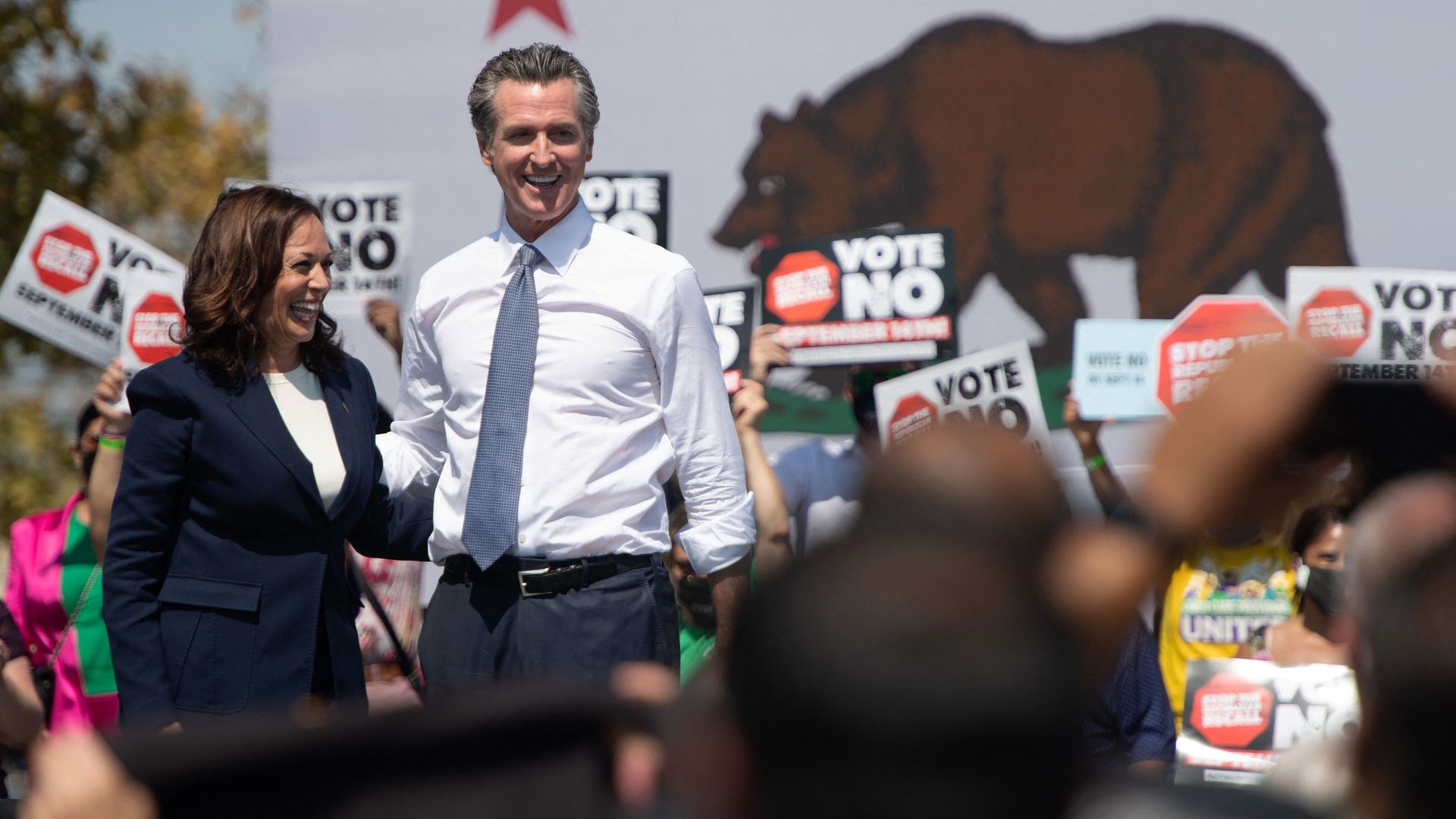 Vice President Kamala Harris and California Gov. Gavin Newsom smile side by side at an anti-recall rally
