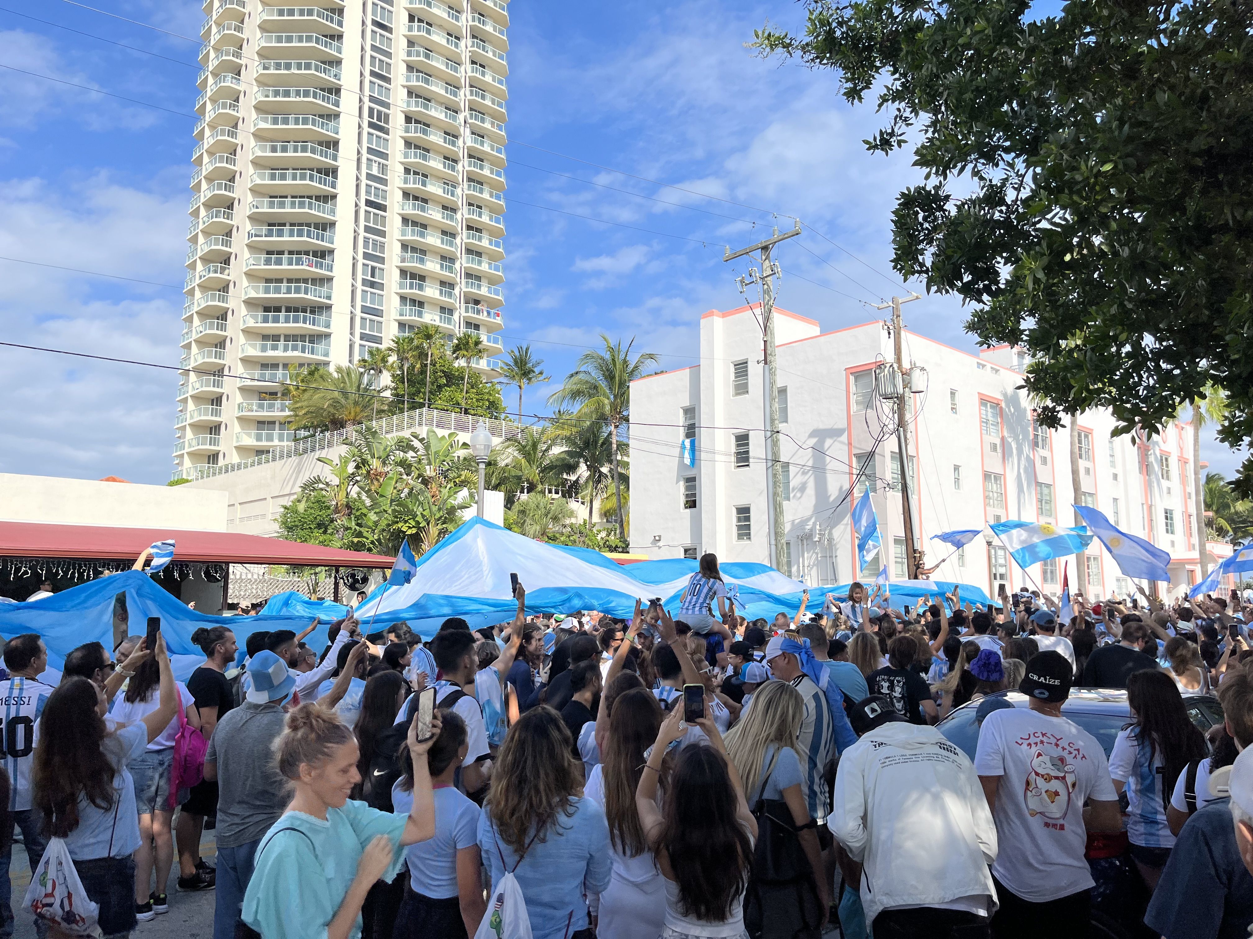 Argentina fans celebrate their World Cup win by waving a giant Argentina flag over the street in Miami Beach.