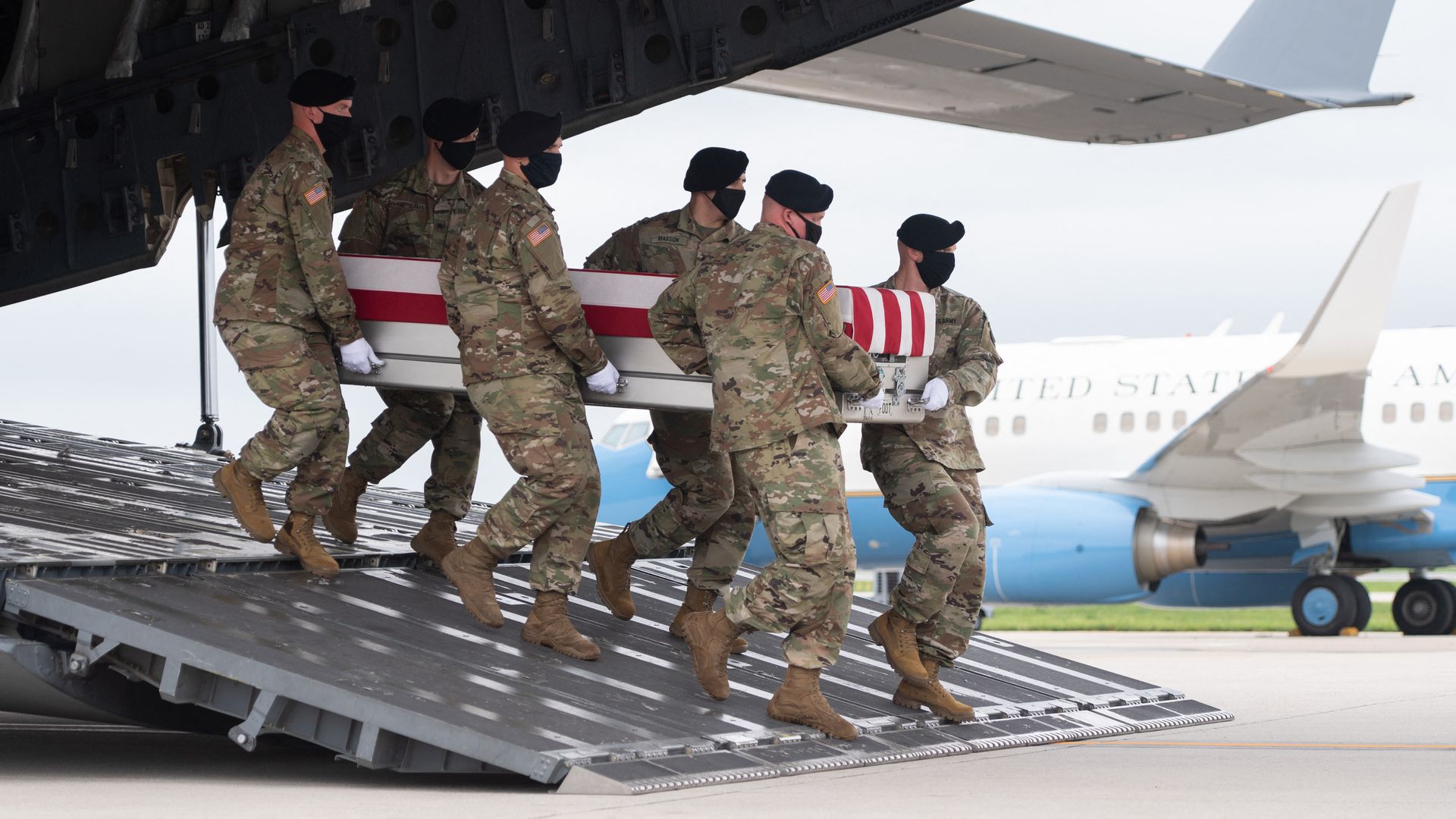 Six U.S. soldiers carry a coffin containing the remains of Army Staff Sgt. Ryan Knauss off a military aircraft.