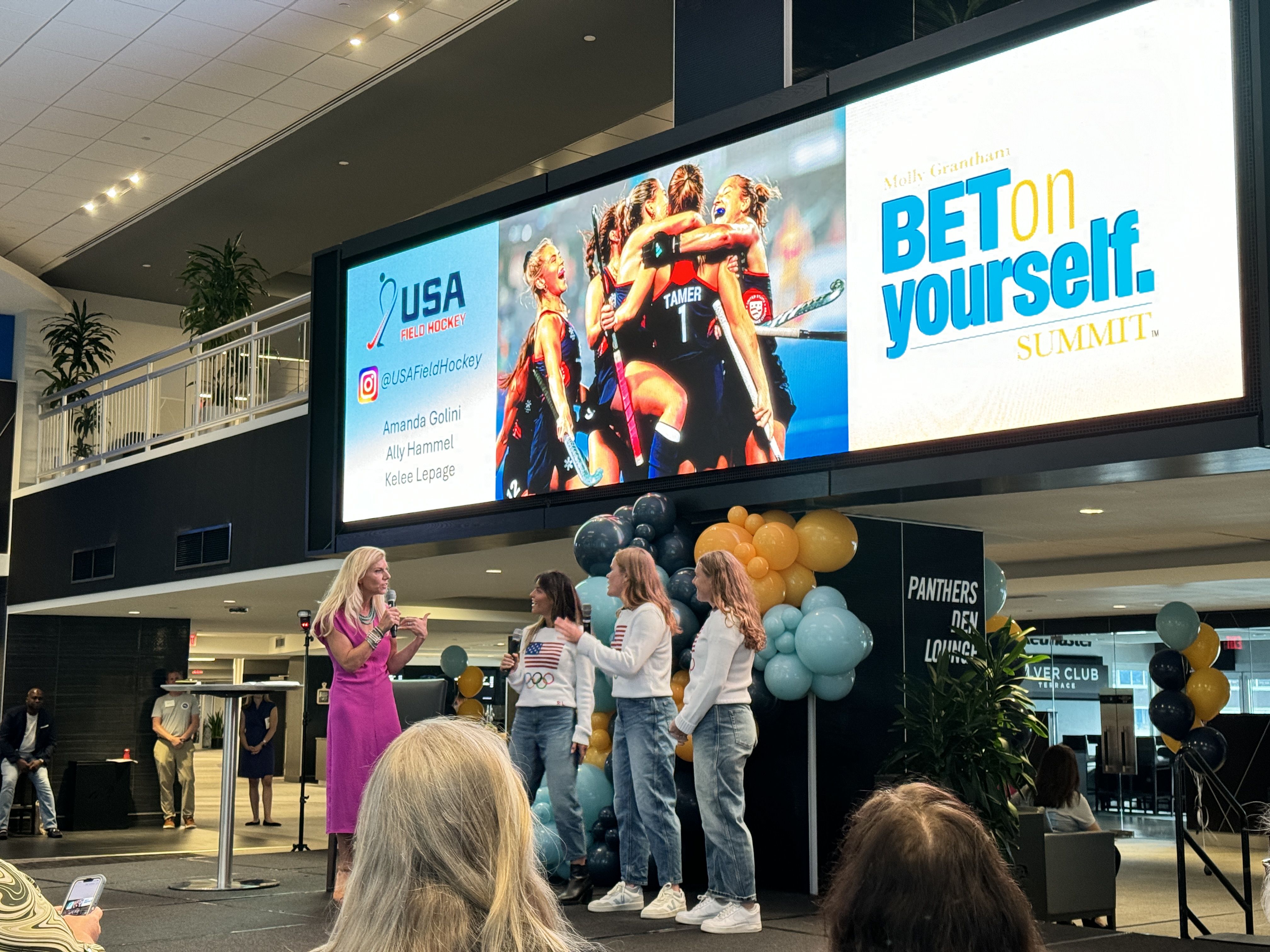 four women stand on stage