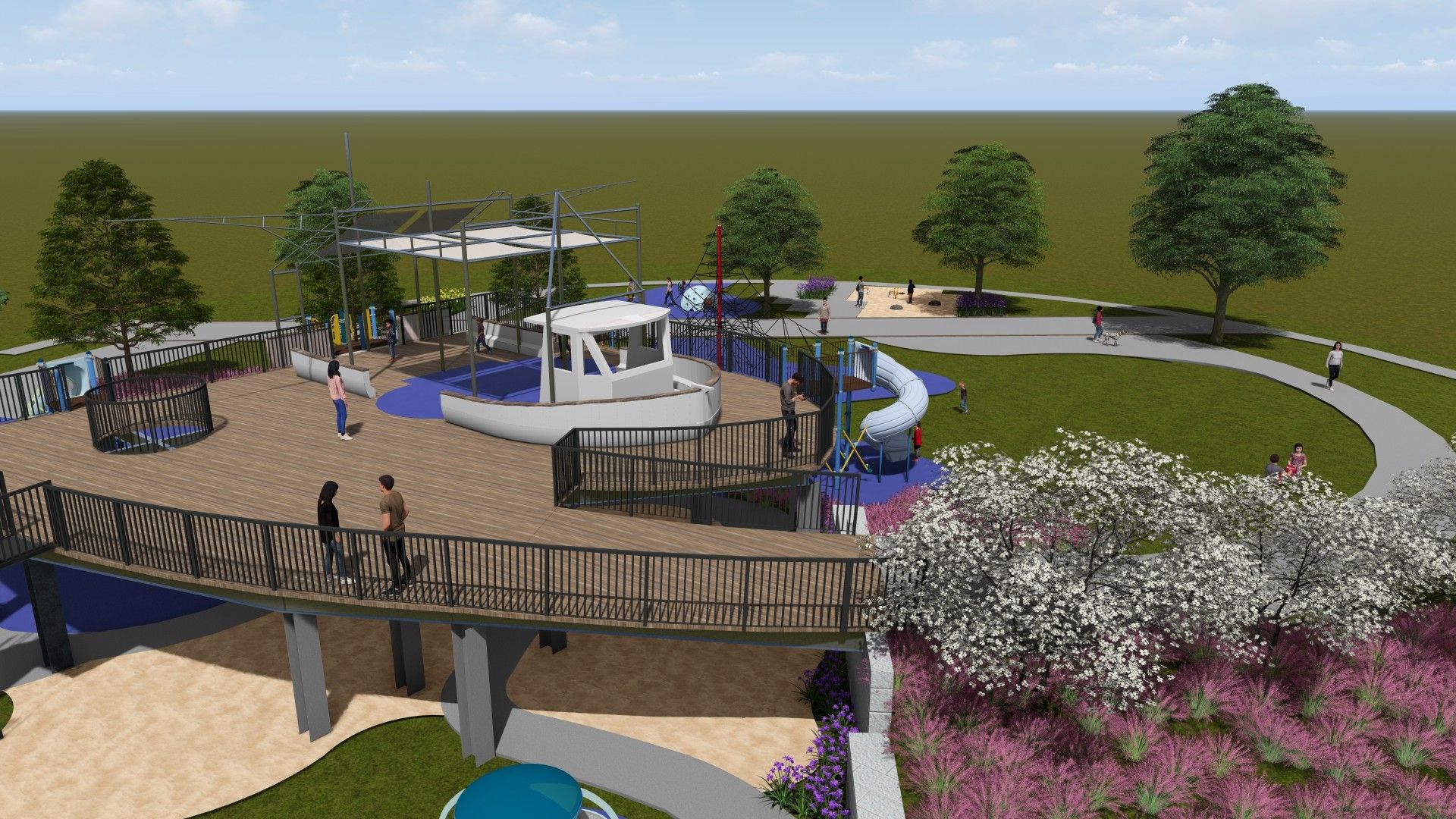 Elevated wooden playground deck shaped like a boat with white railings, blue play mats, slide, and shaded area, surrounded by green trees, grass, and flowering bushes with people walking.