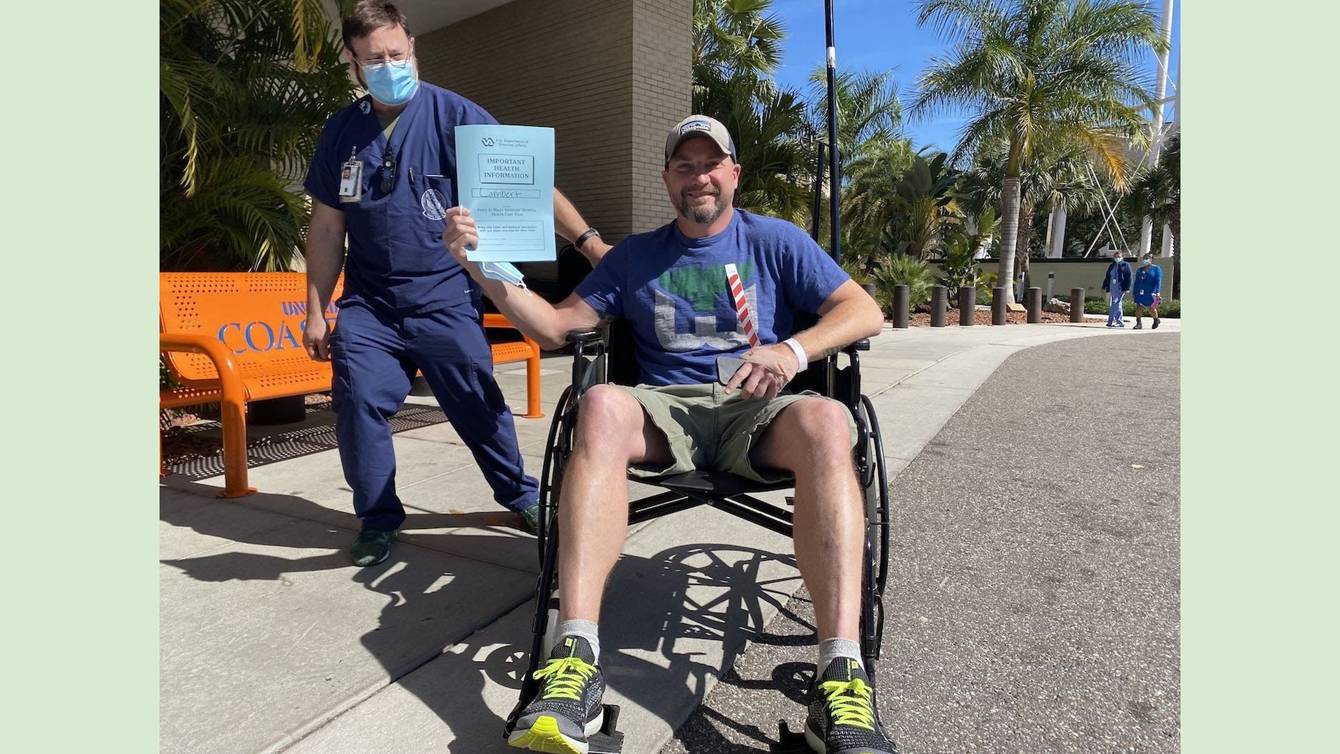 Scott Lambert proudly post-colonoscopy in a wheelchair and holding his health data.