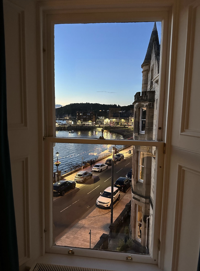 Cars drive along a bay at dusk