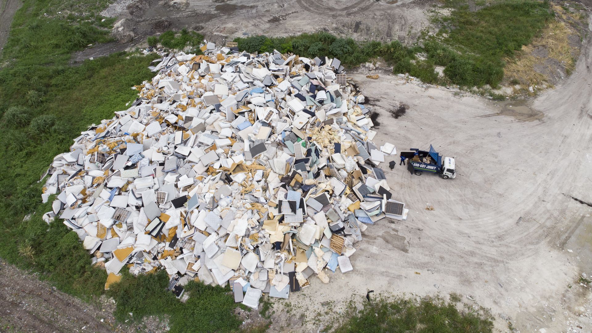 Workers remove garbage from a truck at the Miami Dade County North Dade Landfill in Miami Gardens, Florida