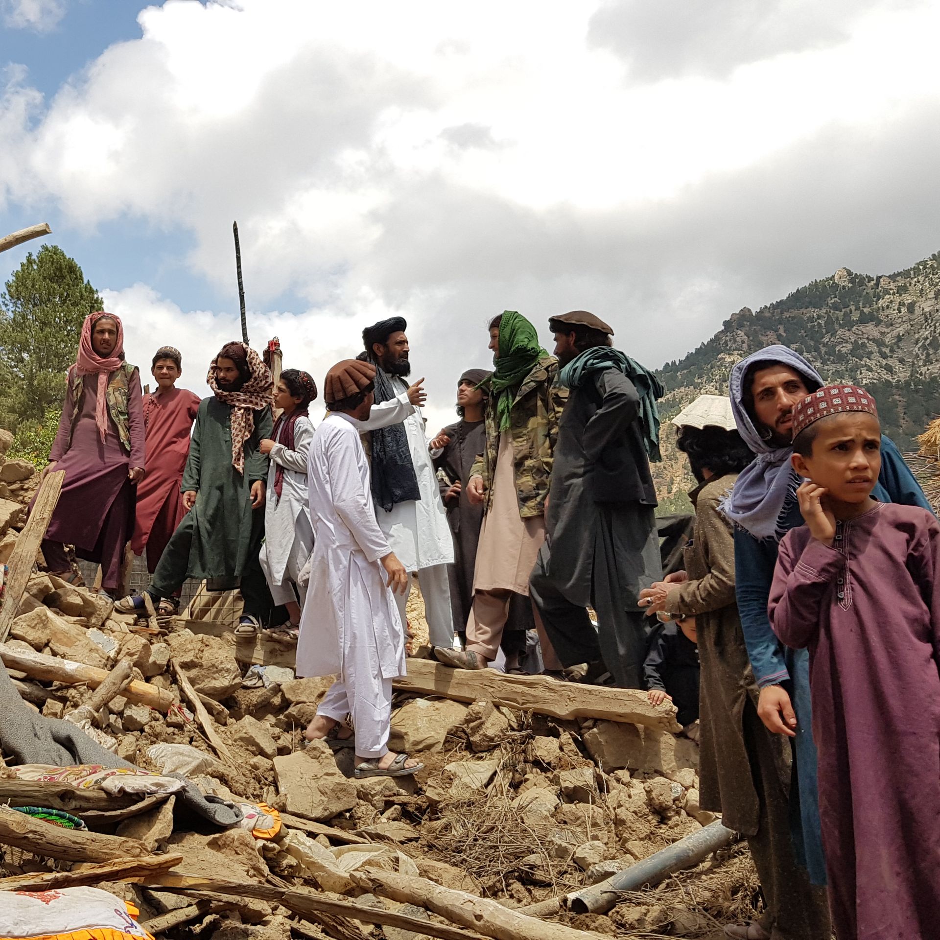 People help for the search and rescue operations on debris of a building after an earthquake shook Afghanistan on June 22. 