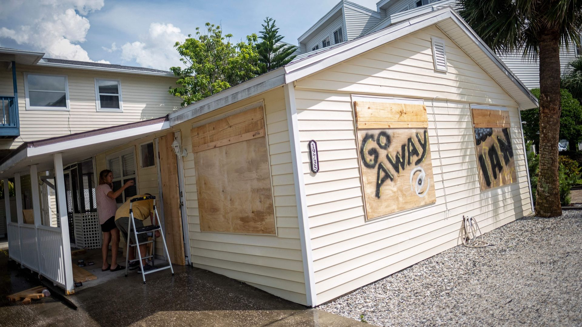 A couple board up windows as they prepare for the arrival of Hurricane Ian in Indian Shores, 25 miles West of Tampa, Florida on September 26.