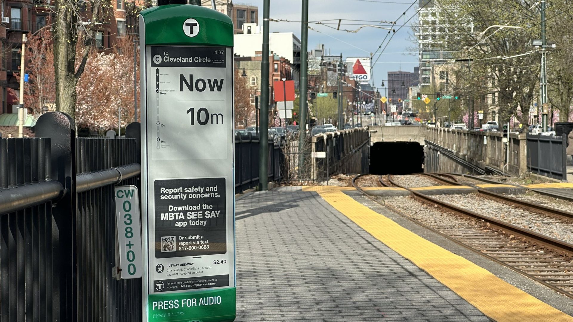 An image of an solar-powered ePaper sign at a Green Line stop on the C branch, showing that a train is arriving now and in 10 minutes. 