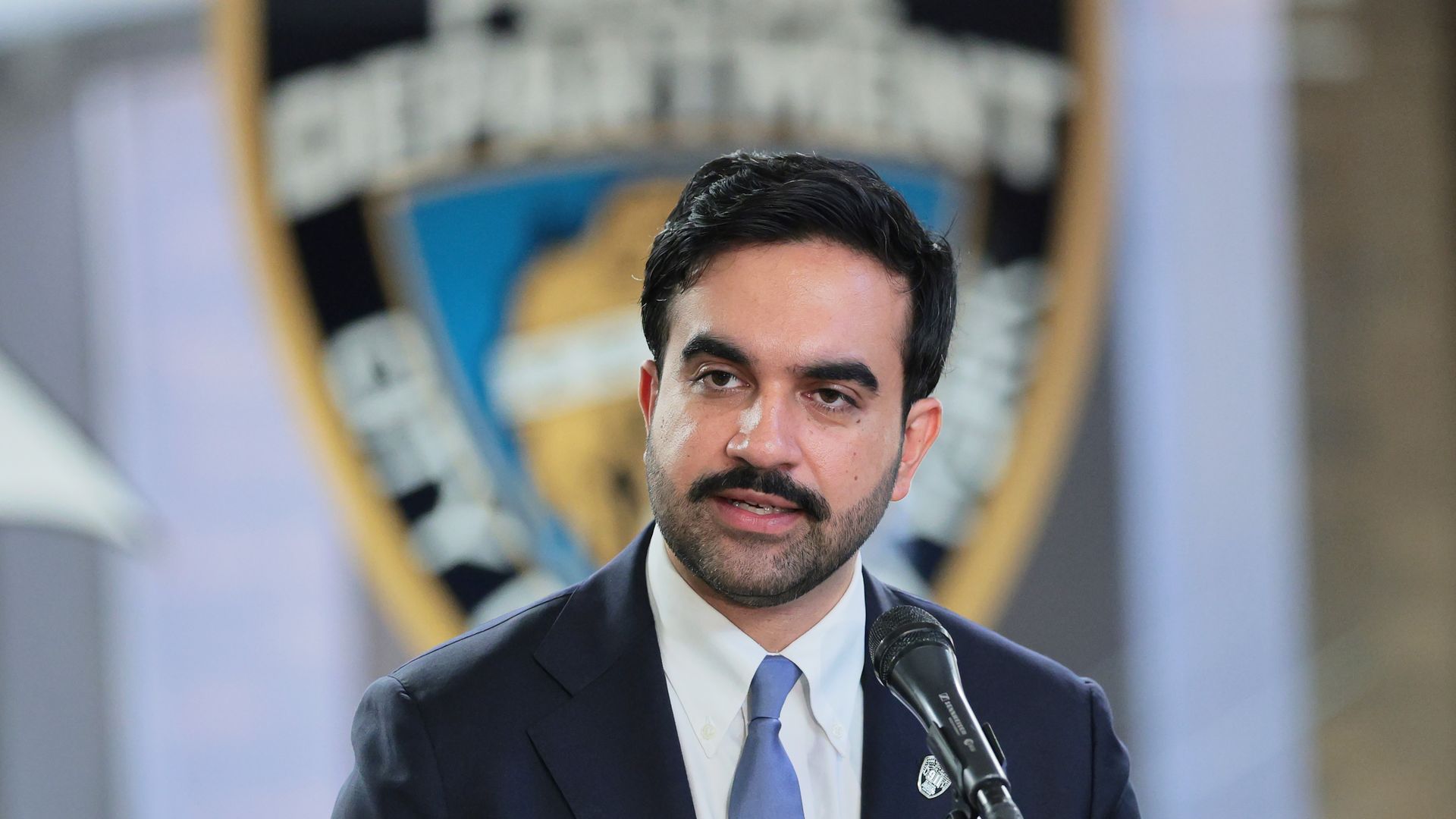 New York City Mayor Zohran Mamdani in front of a New York Police Department sign.