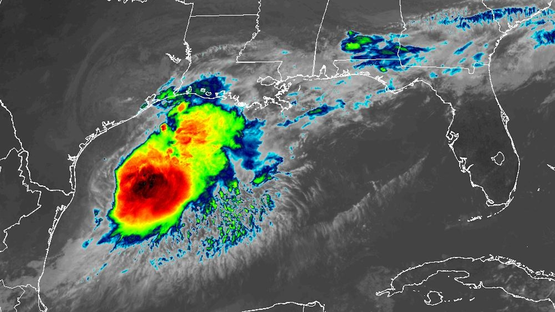 Color-enhanced infrared satellite image of a large tropical cyclone in the Gulf of Mexico west of Florida, featuring a red intense core with yellow-green outer bands amid surrounding clouds.