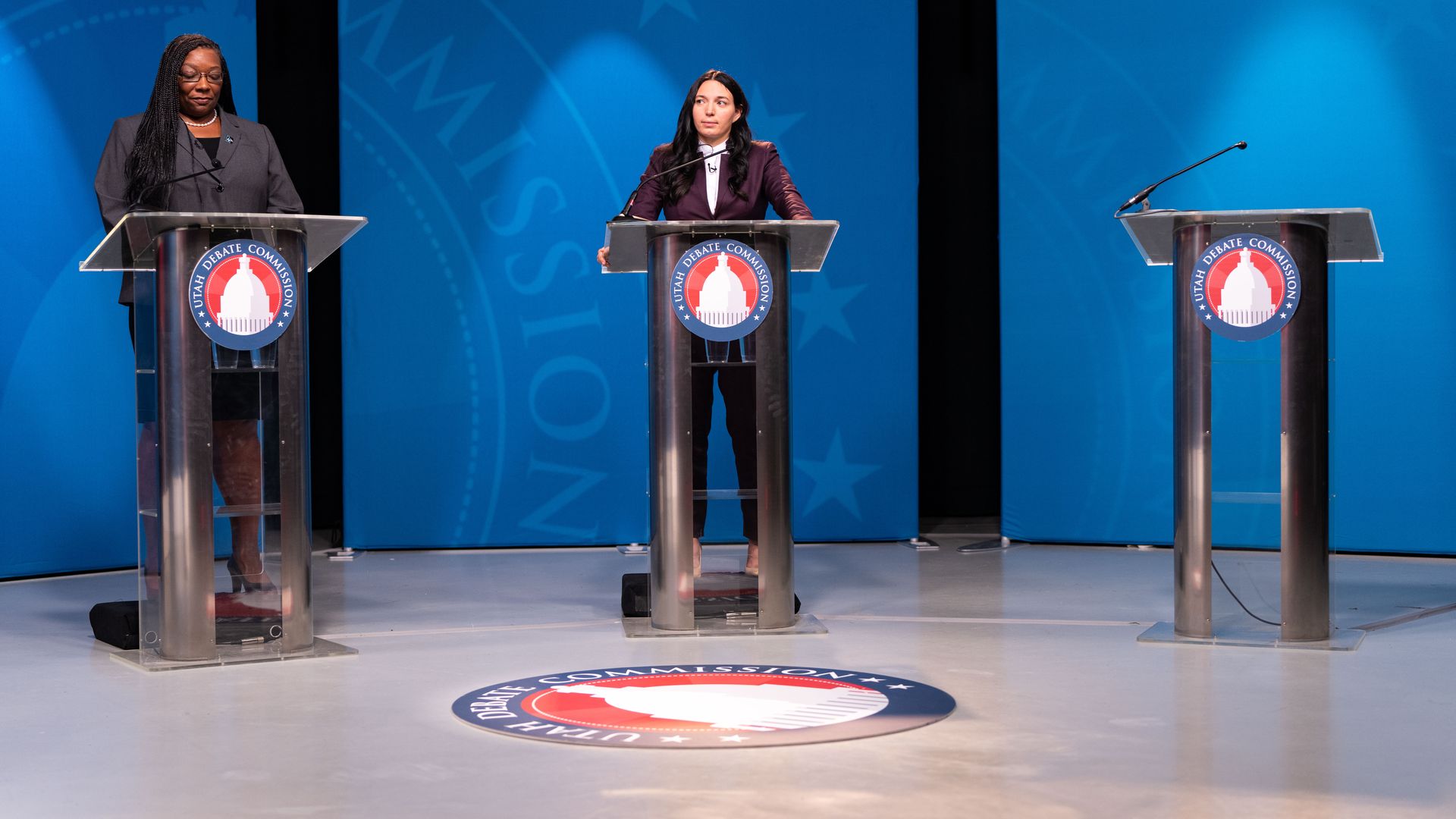 January Walker stands next to an empty podium during a debate.