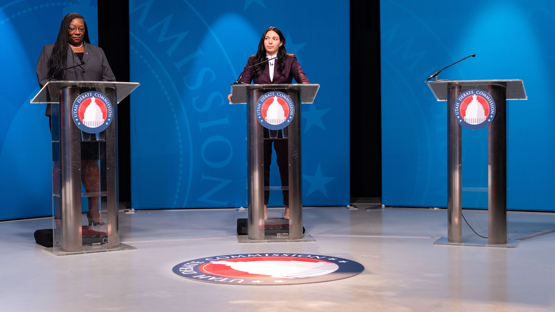 January Walker stands next to an empty podium during a debate.