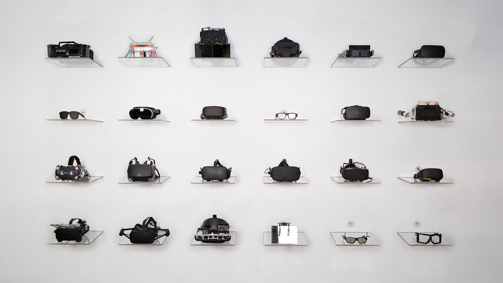 A wall with various Meta prototype VR and AR headsets