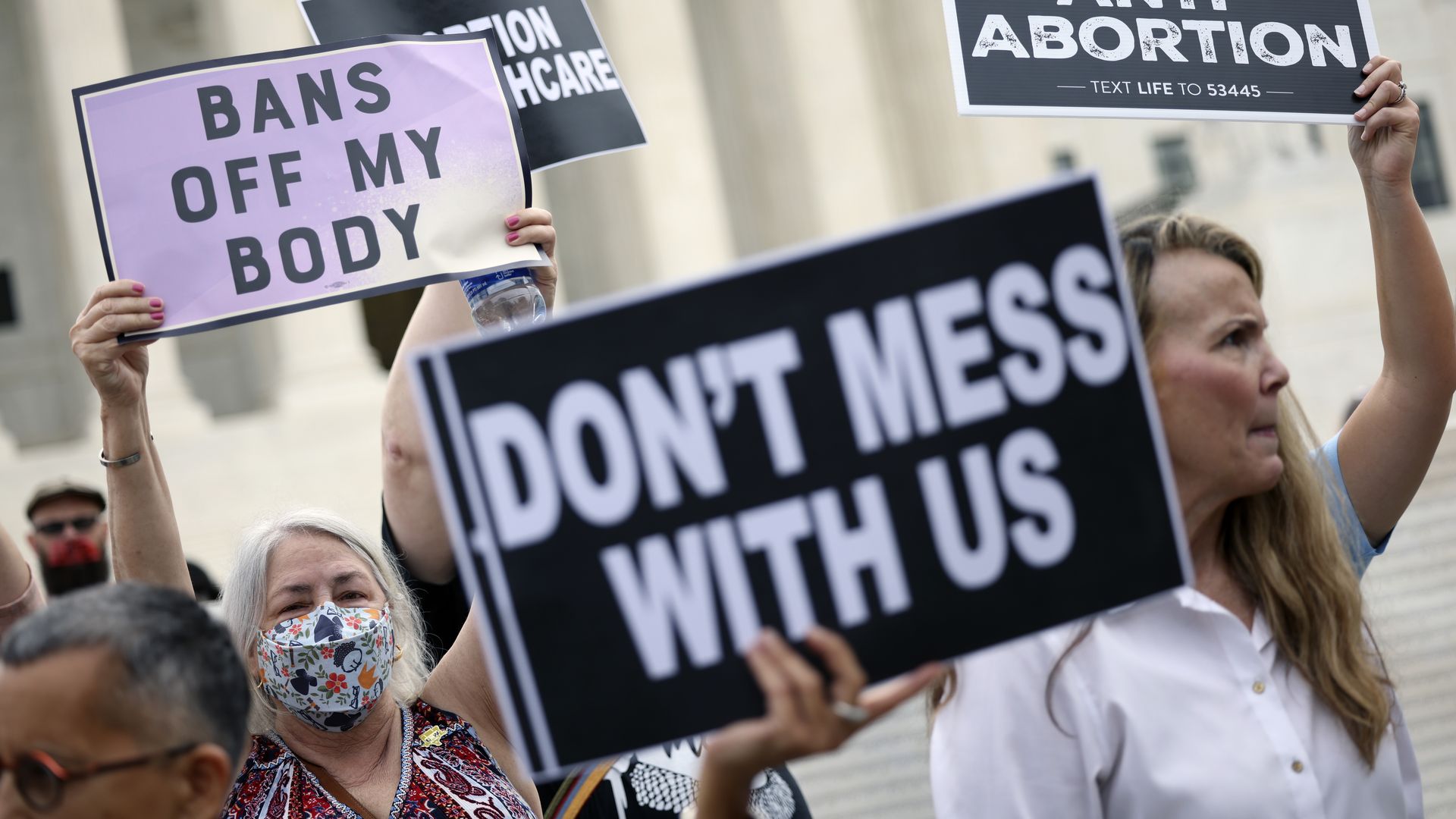 Photo of people holding signs that advocate for abortion
