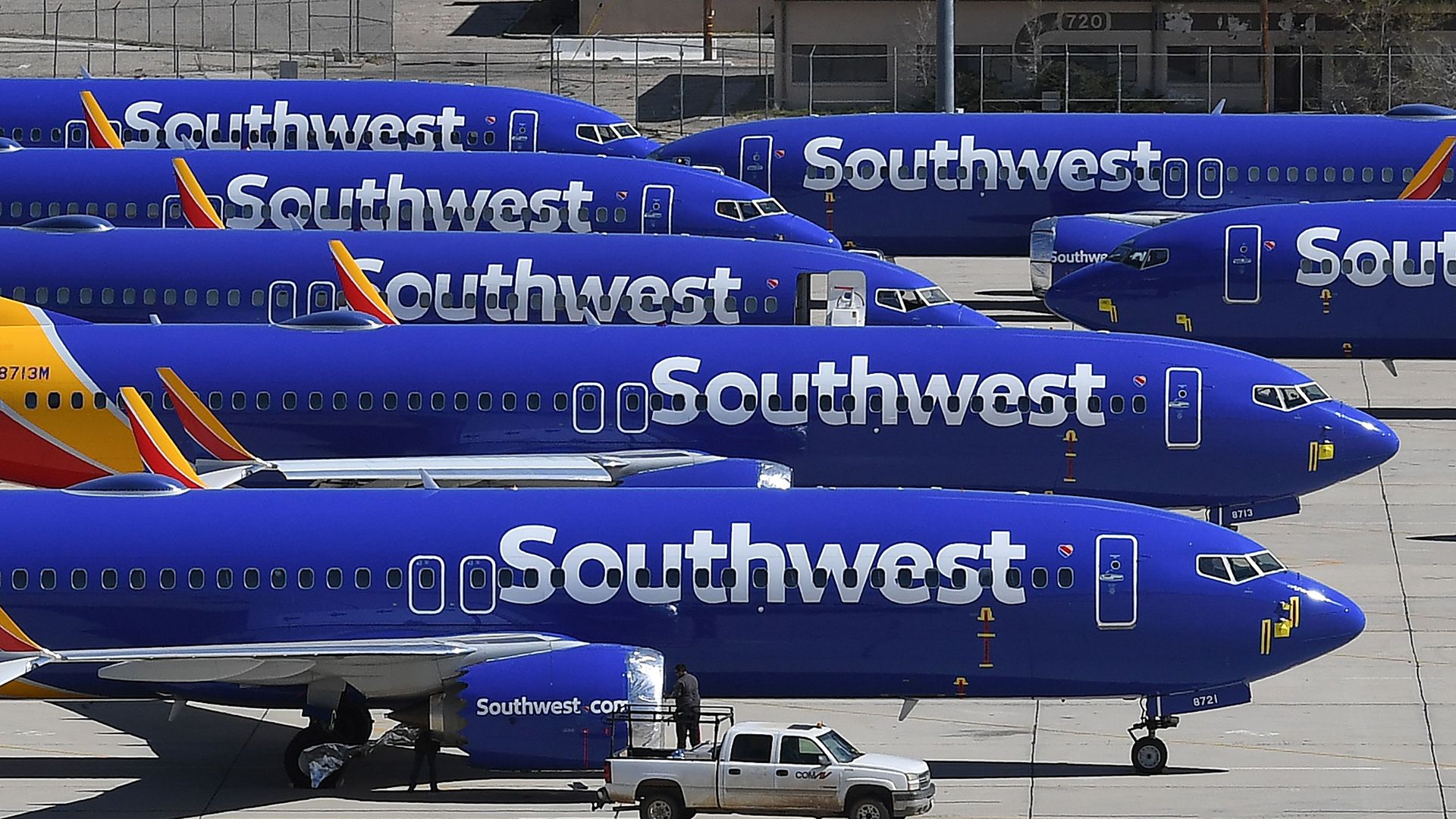 Several blue Southwest Airlines jets are parked on a tarmac.