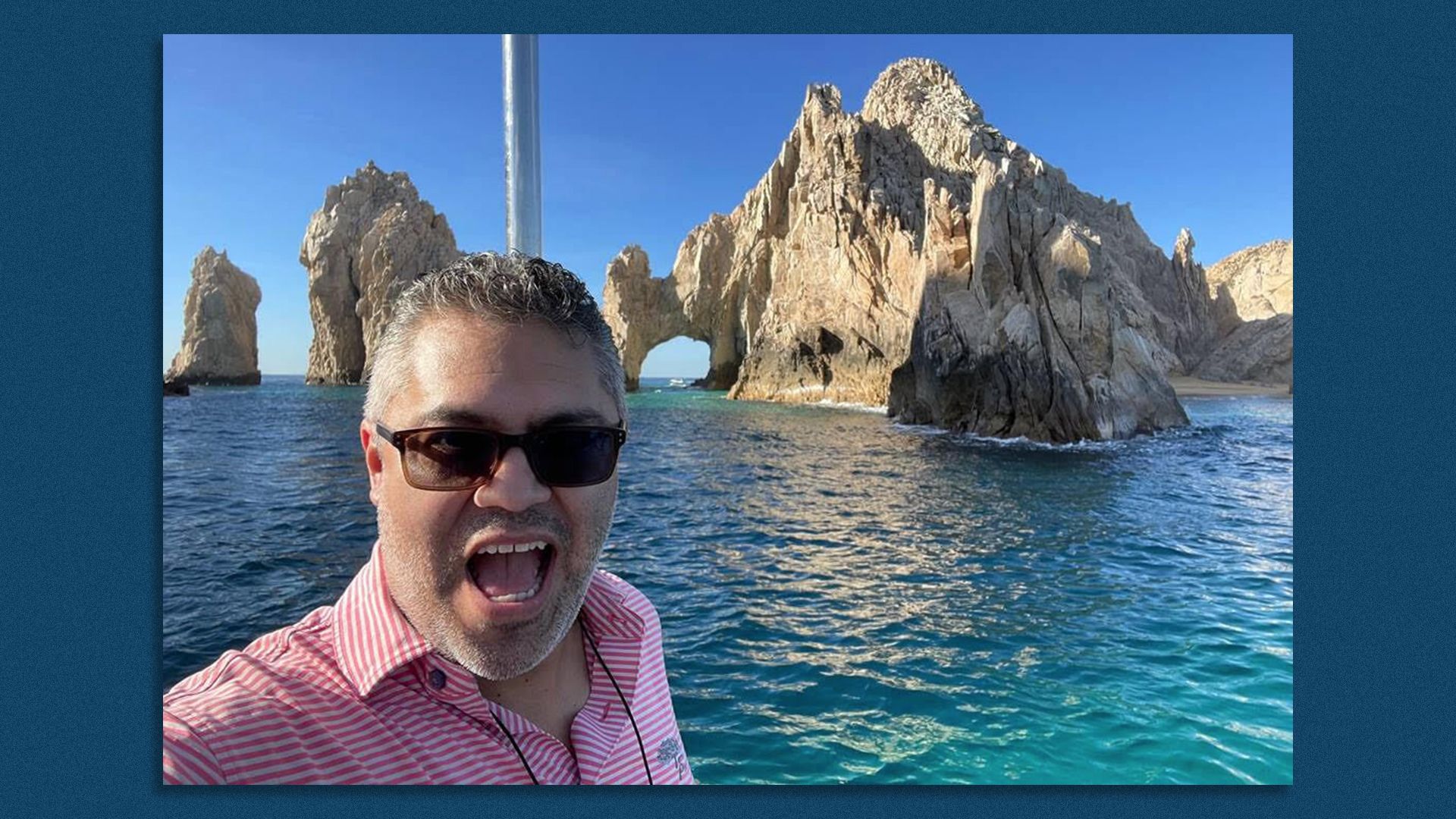 Roberto Deleon smiles while standing near the ocean