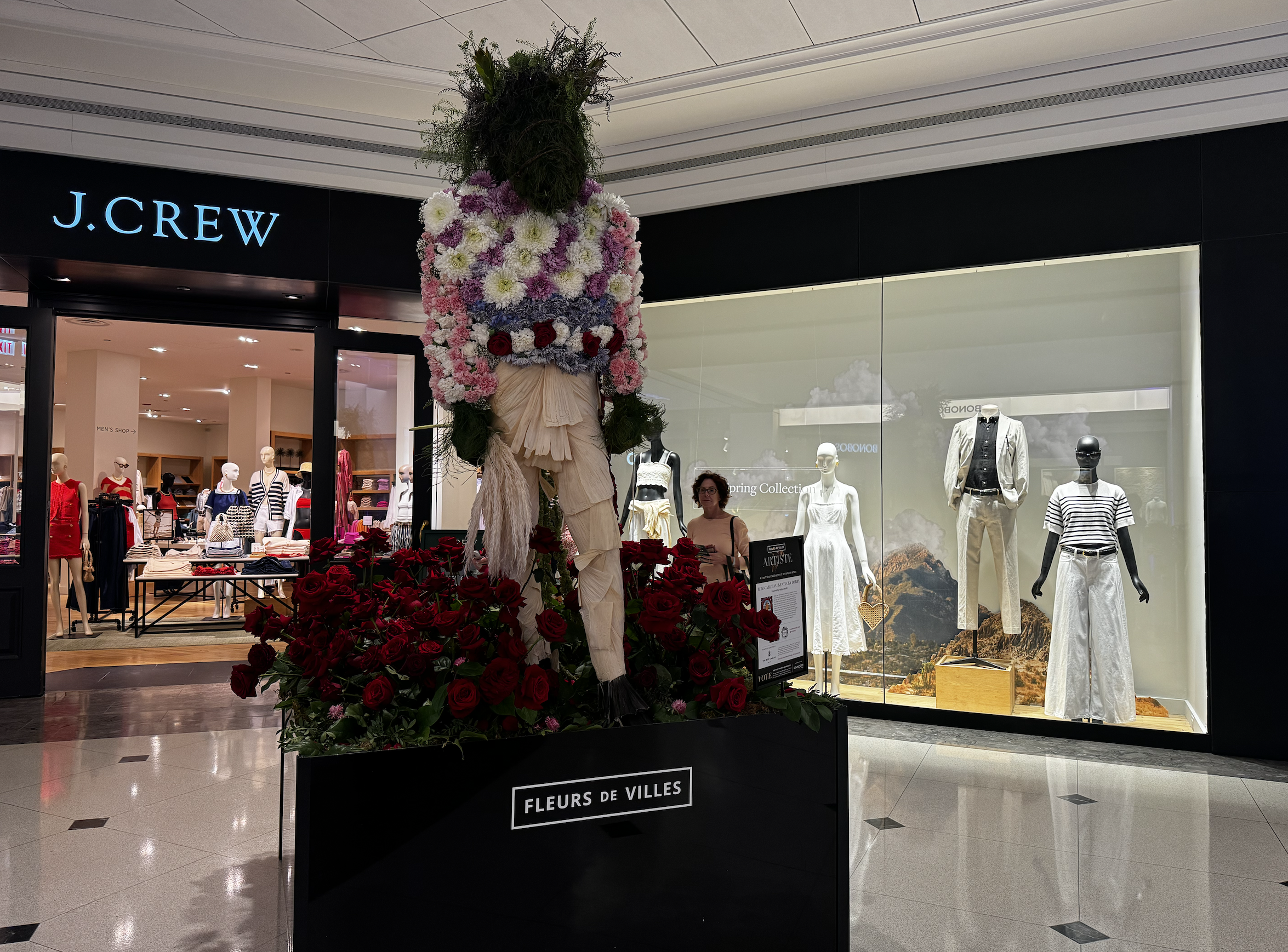 Photo of a mannequin with flowers surrounding it 
