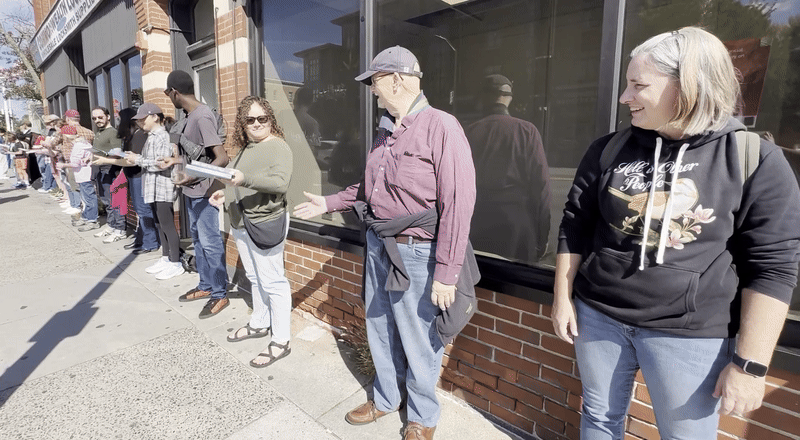 People lined up near Lesley's University Hall pass books down to one another, forming a human book chain in Somerville, Massachusetts.