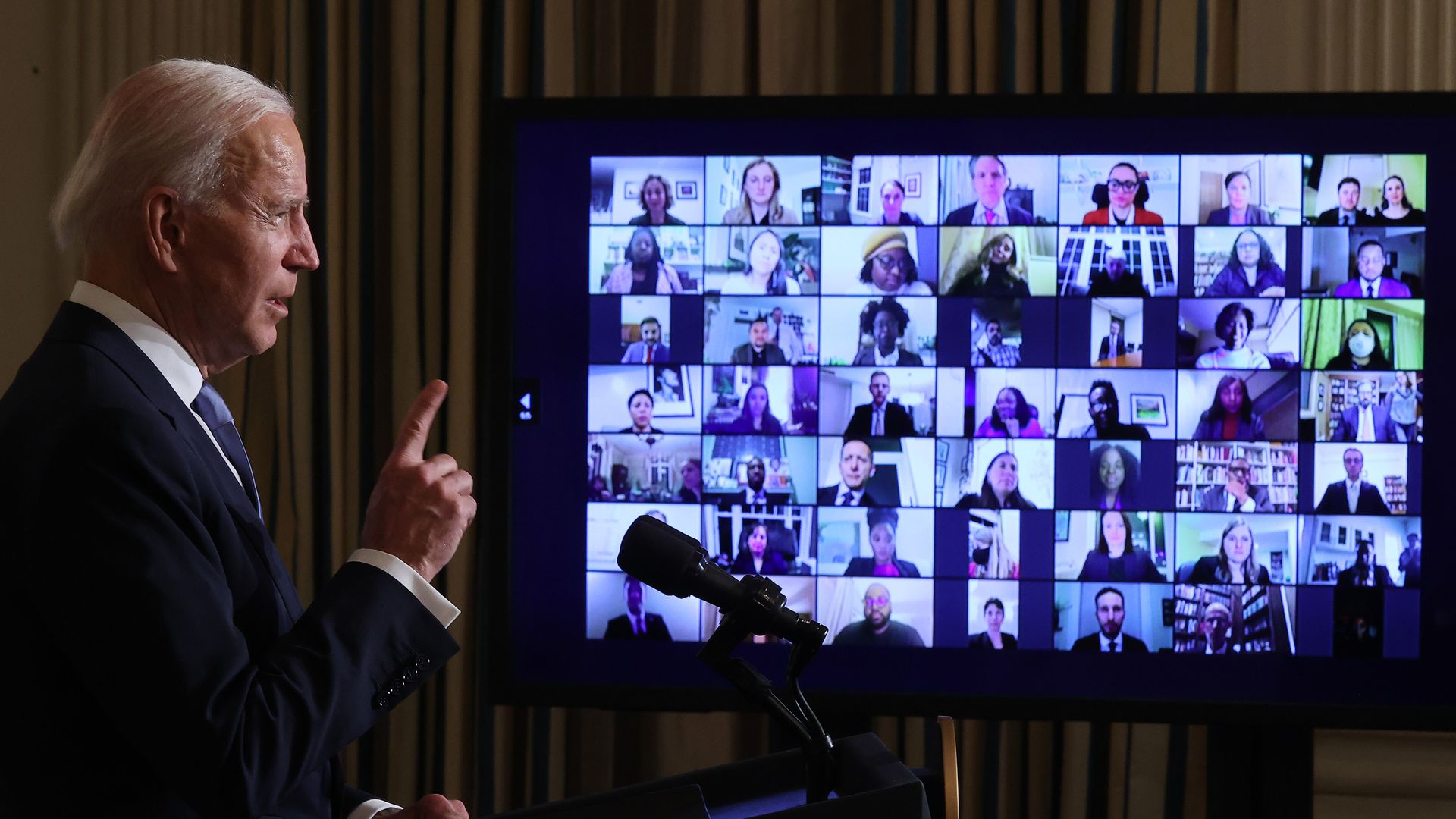Photo of Joe Biden speaking to a screen filled with faces of incoming staffers and appointees