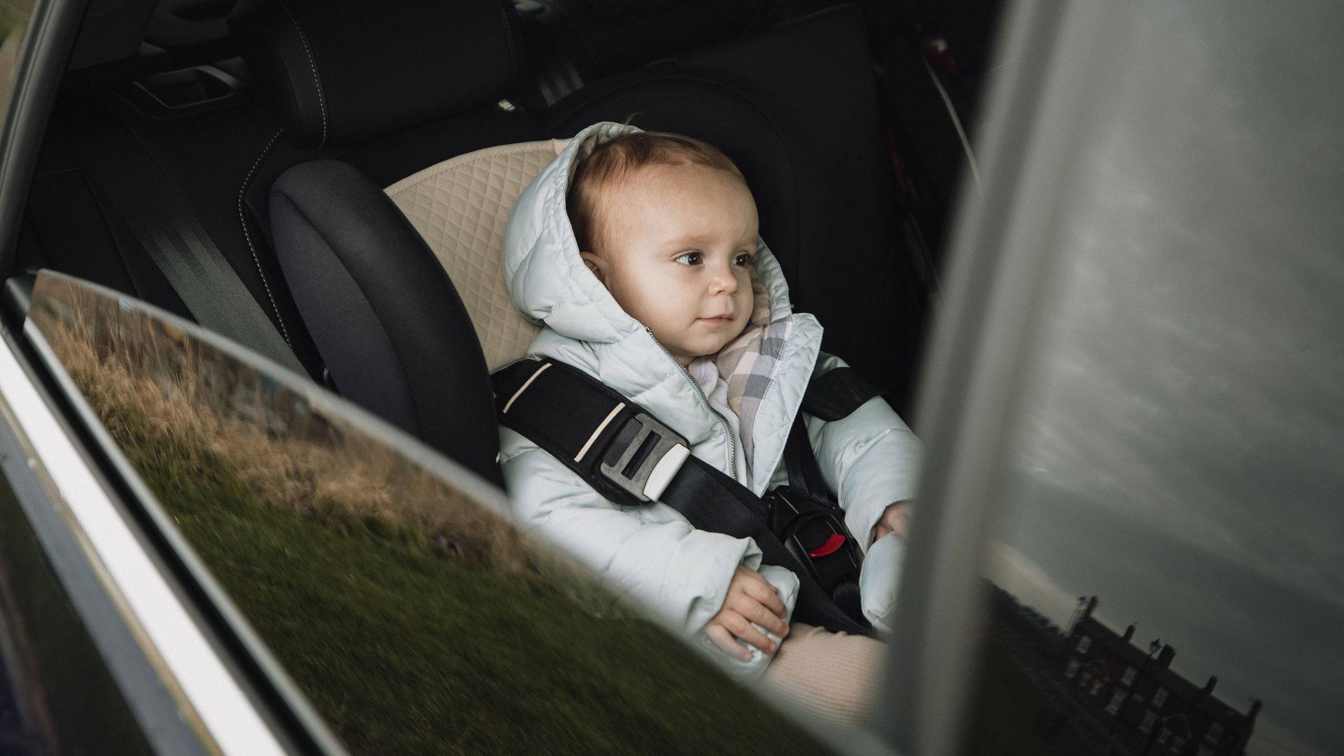 Image of a baby in a car seat in a vehicle. 