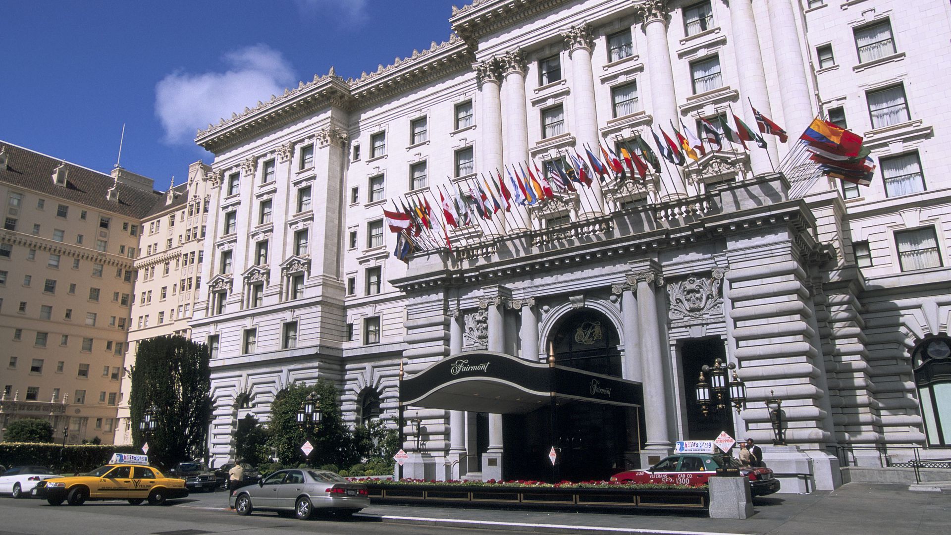 Photo of the entrance to Fairmont Hotel, with several international flags hanging from the balcony