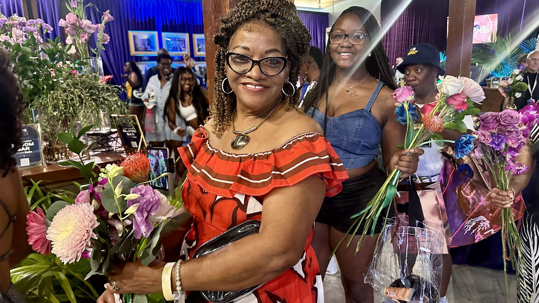 Photo shows women with flower bouquets.