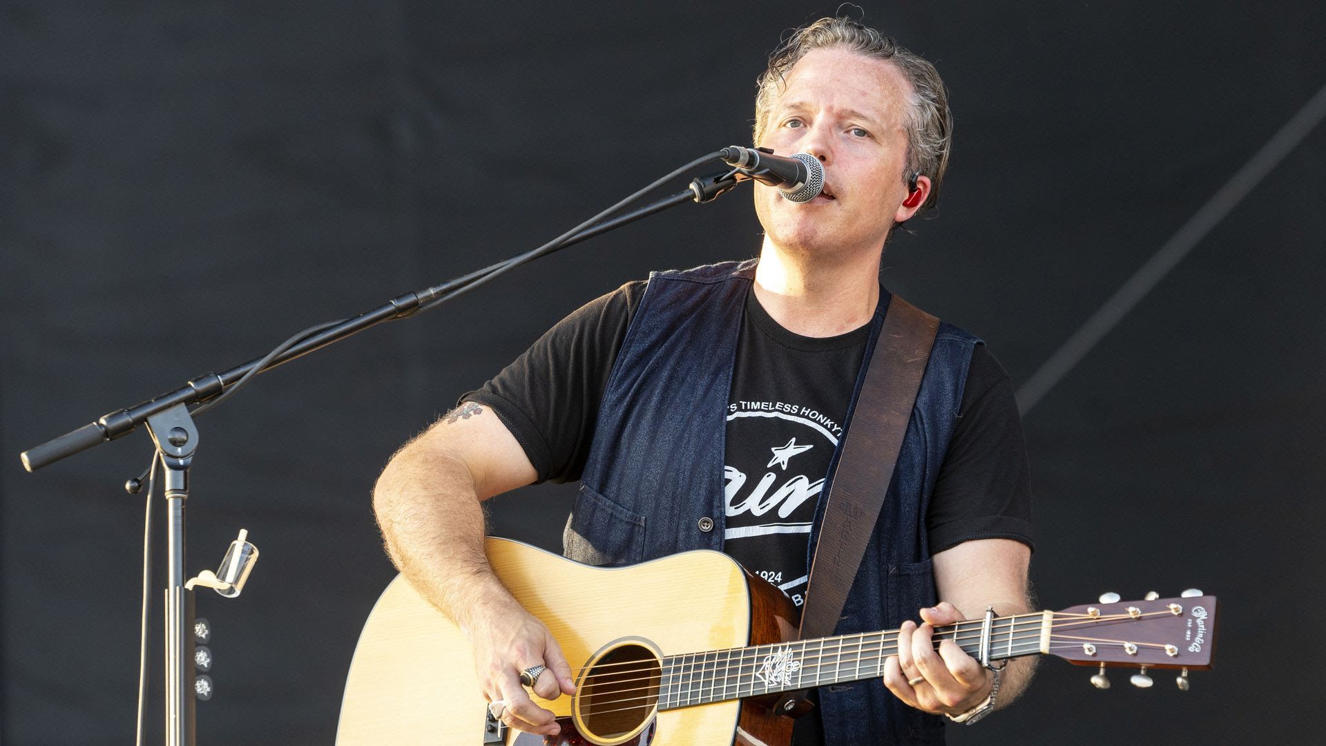 Jason Isbell singing and playing guitar at an event in August.