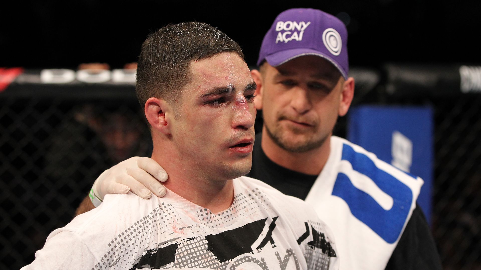 Trainer Greg Jackson appears with a battle-scarred MMA fighter Diego Sanchez after a fight.