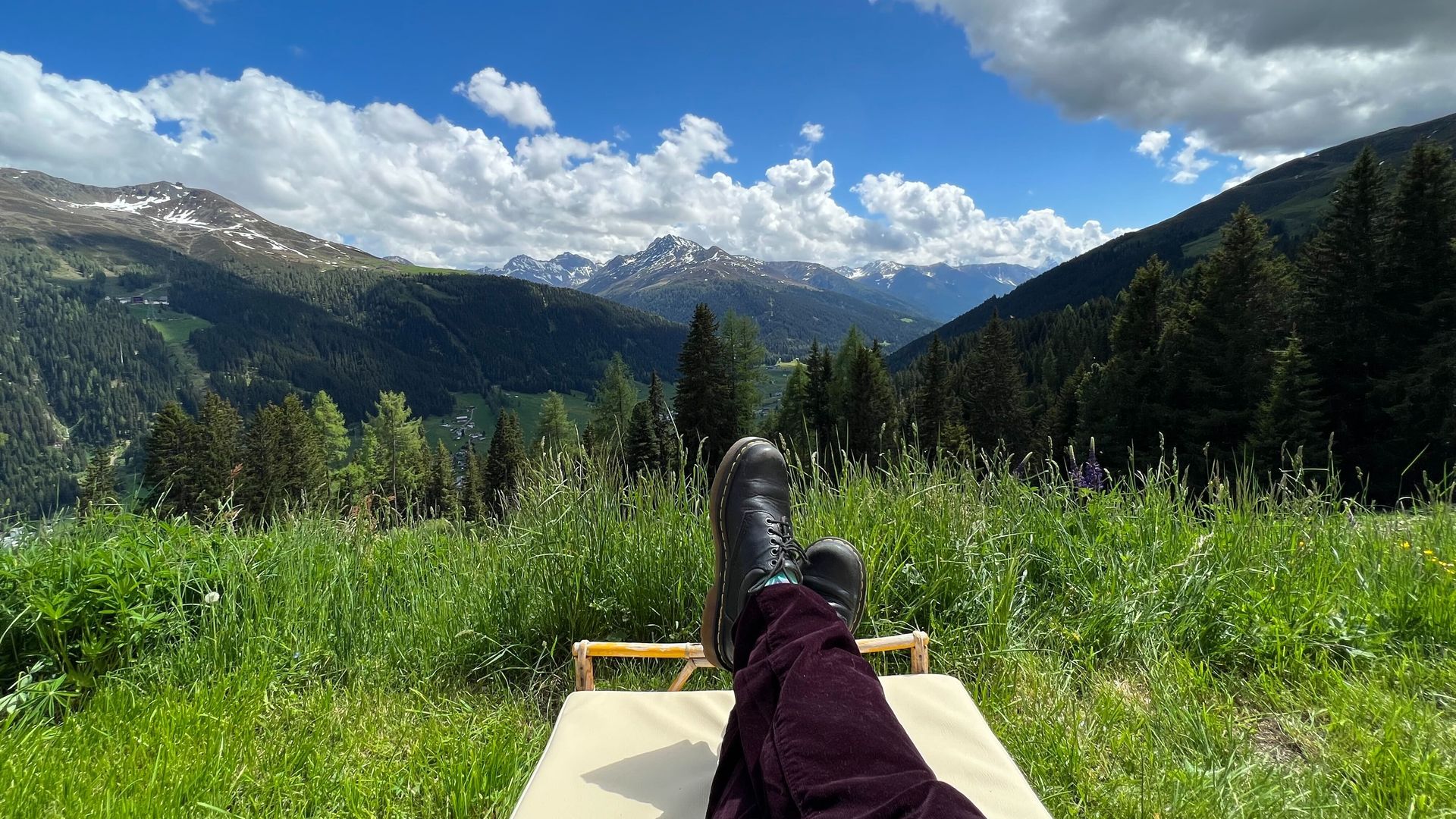 A woman in burgundy pants enjoys a stunningly gorgeous May afternoon in the mountains of Davos