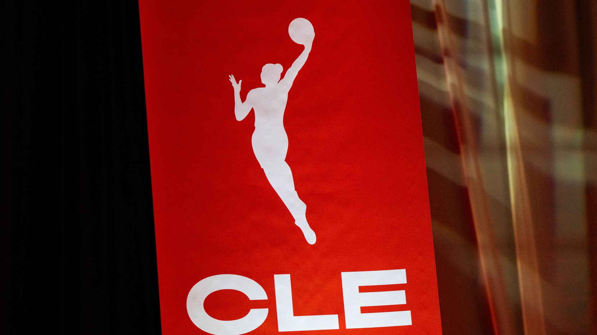Red vertical banner with a white silhouette of a jumping basketball player dunking, and the letters CLE at the bottom.