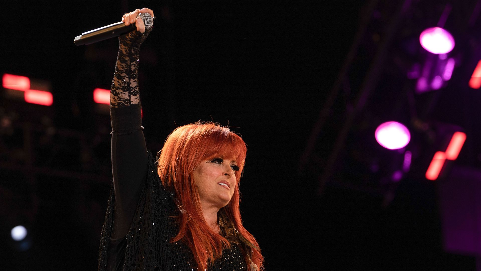 Wynonna Judd holding a microphone.