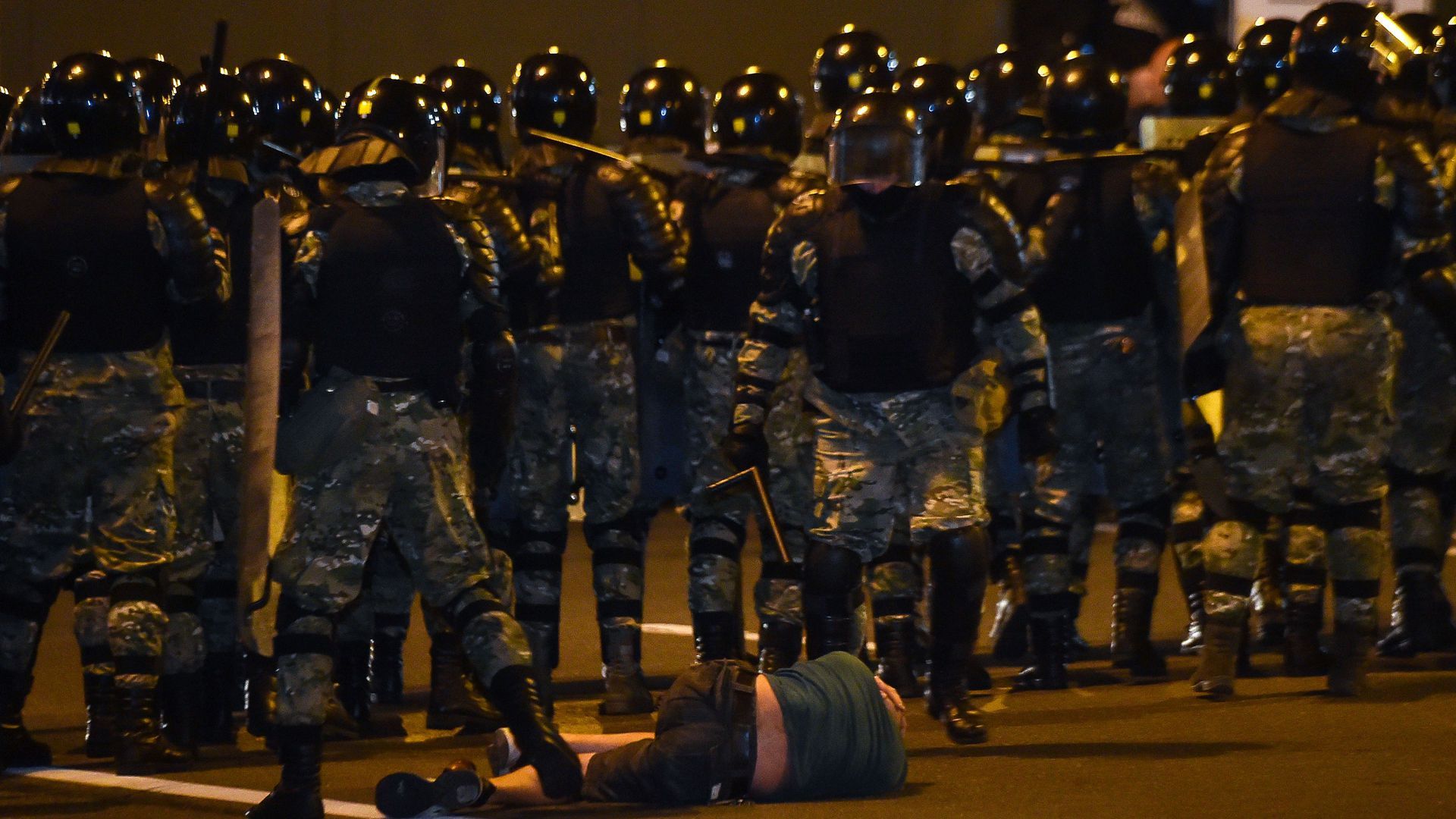 A man lies on the ground in front of riot police in Minsk. 